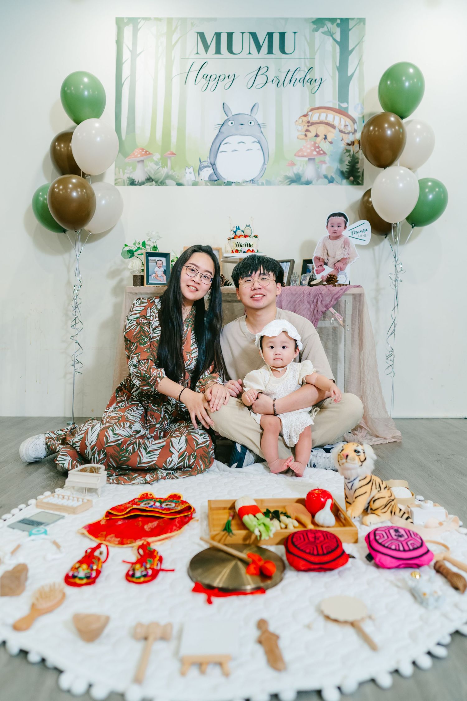 Baby birthday party decoration featuring Totoro theme with green and white balloons, dessert table, and party decor setup.