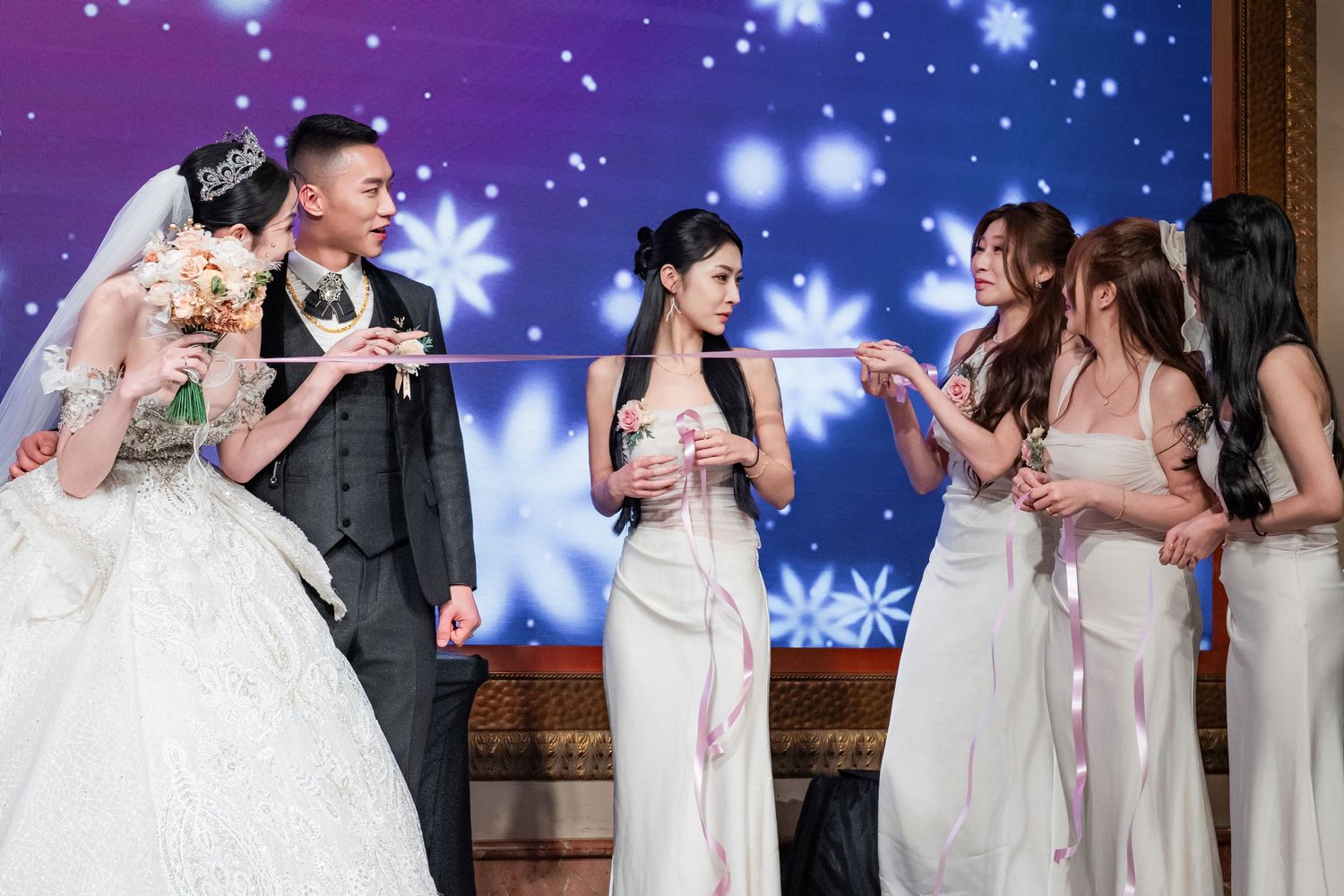 A wedding celebration with people in formal attire holding drinks and socializing at an elegant evening reception.