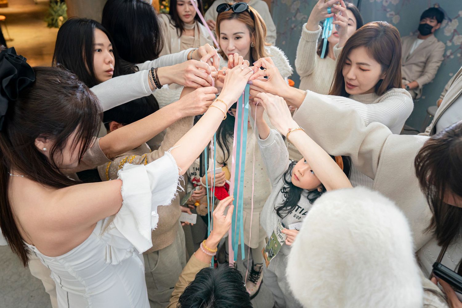 People dancing together in pairs at a social gathering or dance event with white decor and festive atmosphere.