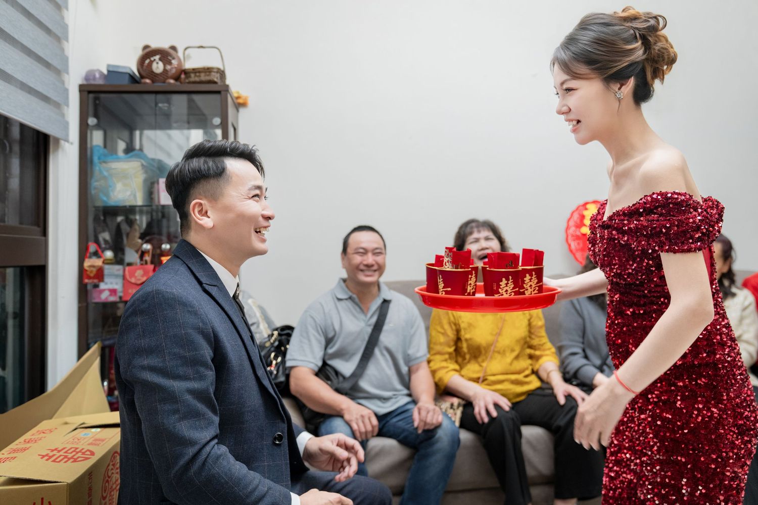 Wedding guests enjoying a traditional Chinese tea ceremony during a celebration.