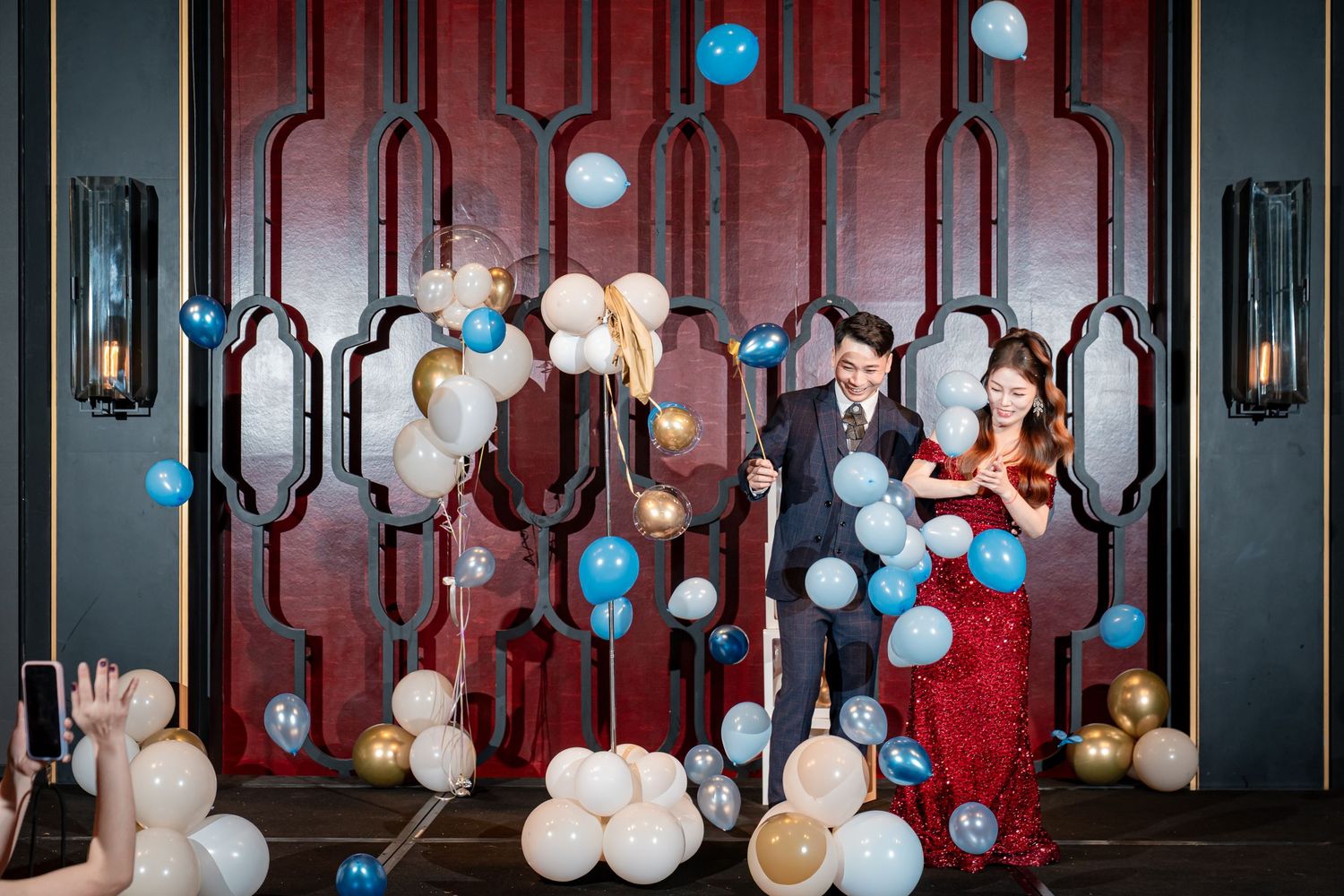 Elegant wedding reception venue decorated with hanging light bulbs and chandeliers creating a romantic atmosphere.