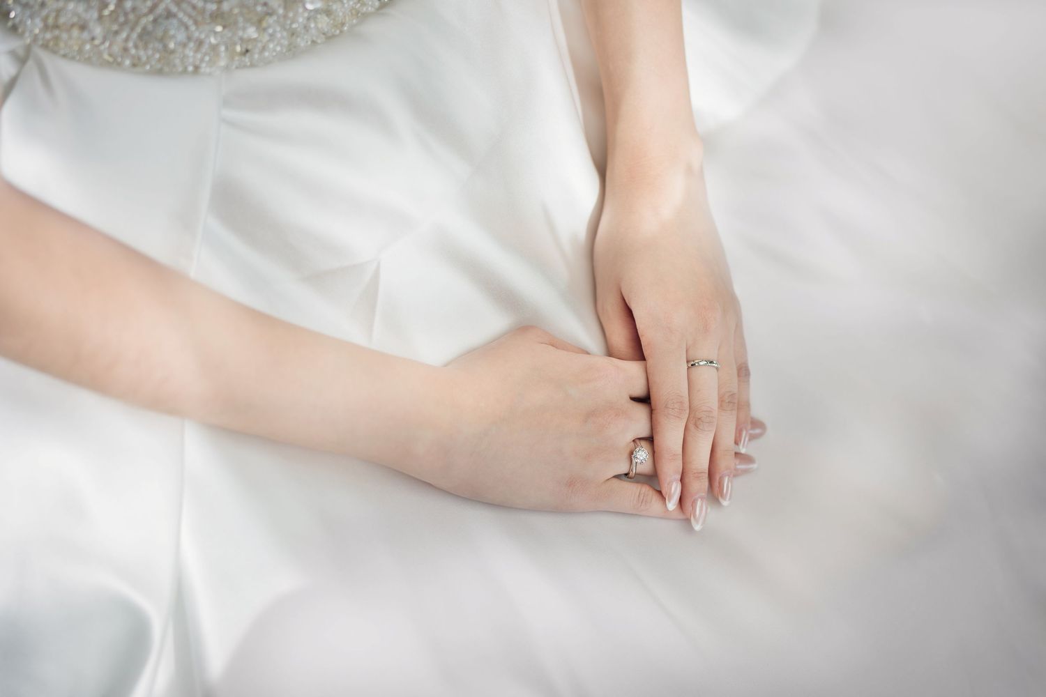 Close-up view of delicate lace details and embroidery on a white wedding dress.