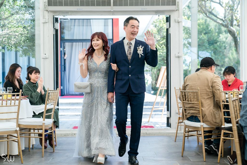 Wedding party entrance with joyful expressions down venue aisle.