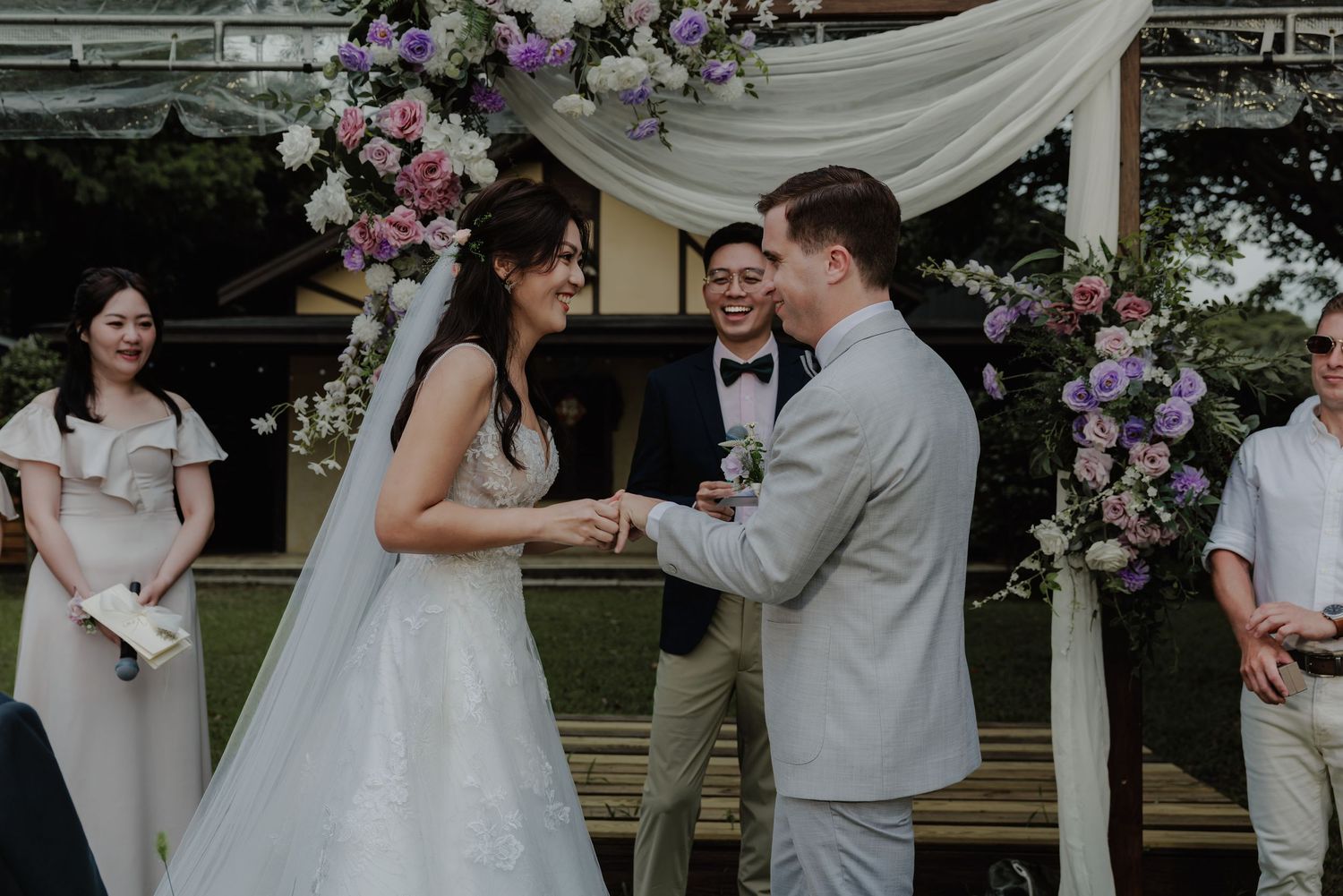Bride and groom exchanging vows at outdoor wedding ceremony under floral arch with purple and white flowers.

台北婚禮攝影
婚禮攝影師
戶外婚禮
婚禮紀實
婚攝推薦
台灣