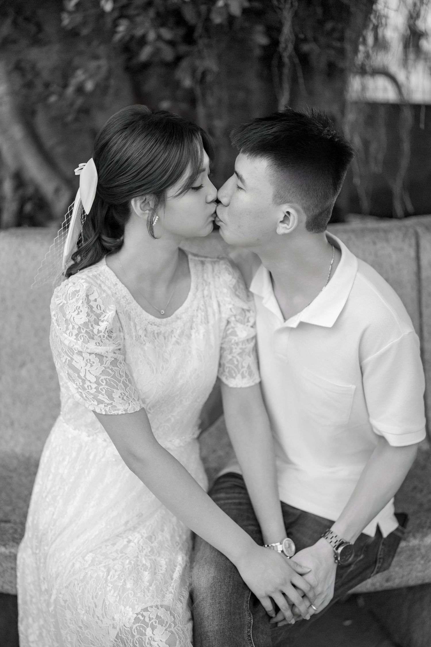 A romantic black and white photo series showing a couple in white attire sharing tender moments together.