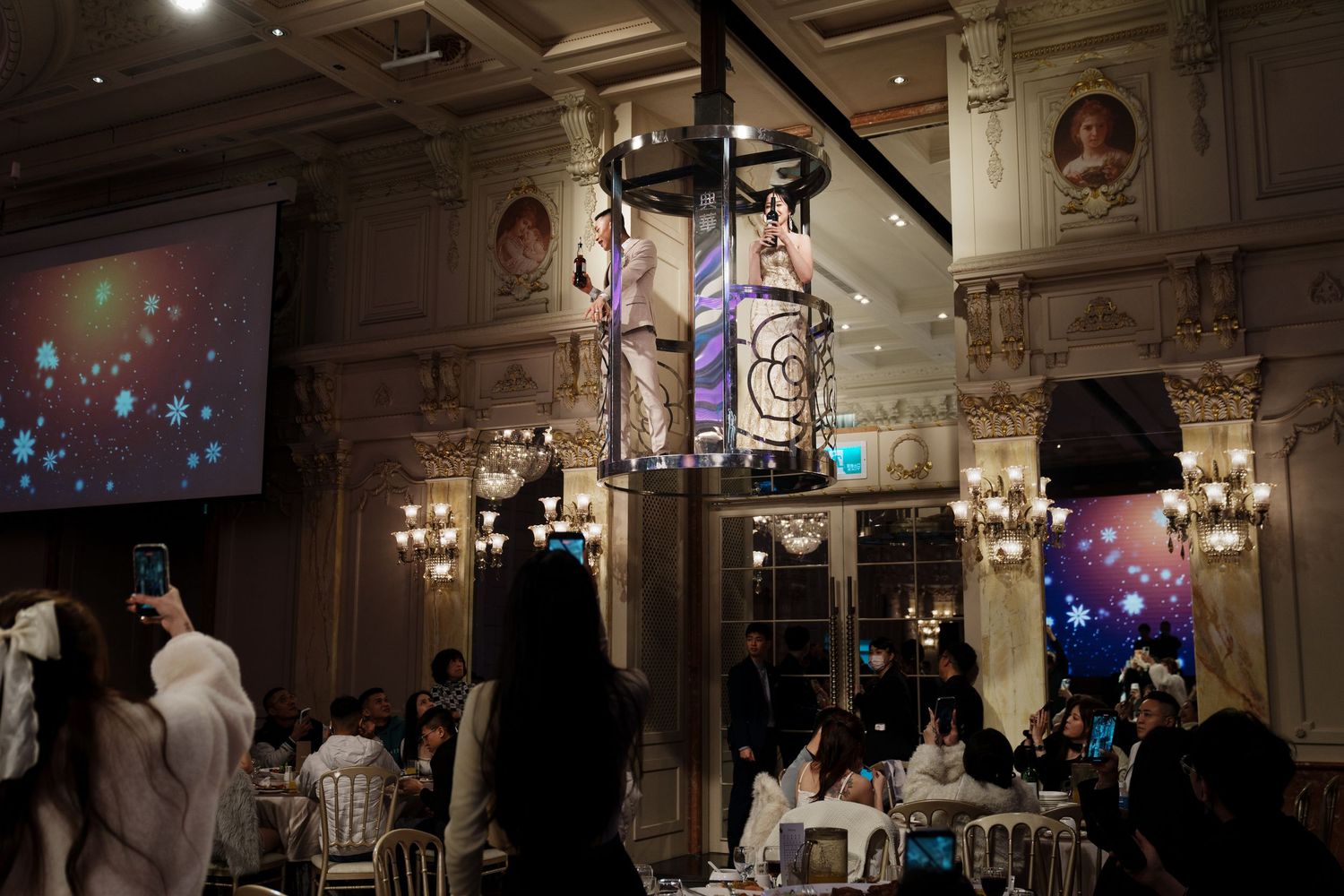 Elegant ballroom venue with crystal chandeliers and colorful party lighting creates a festive atmosphere for an event.