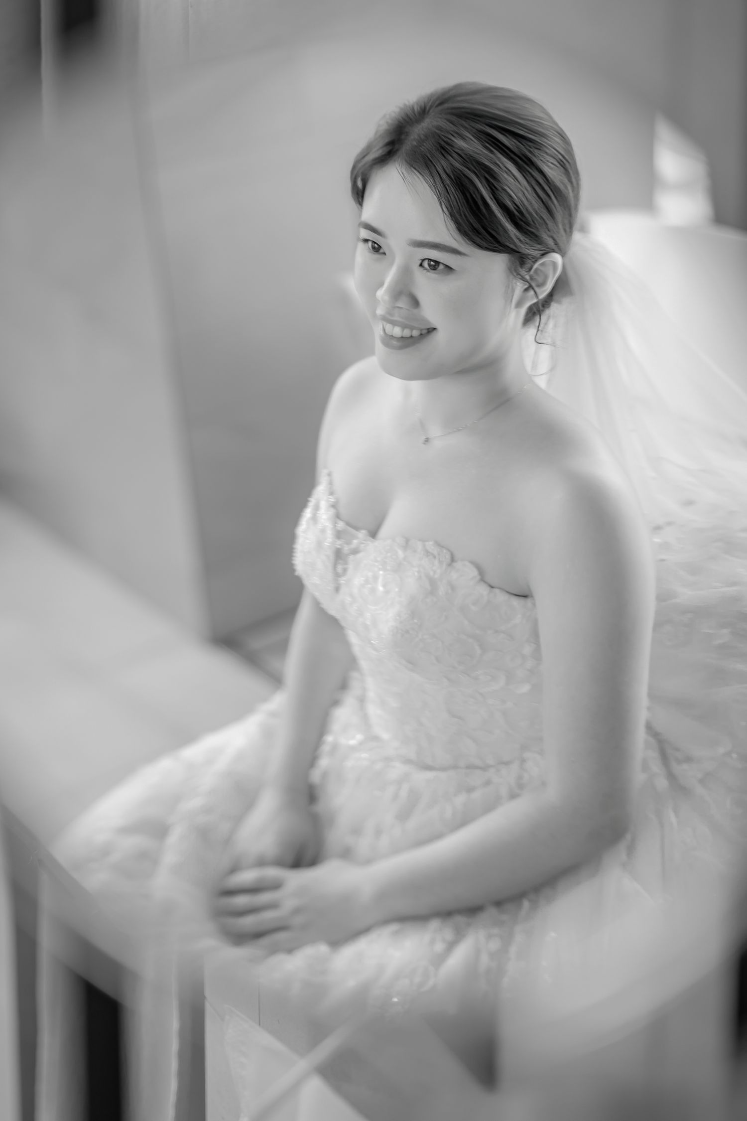 A series of soft black and white photographs showing a bride in a delicate lace wedding gown with elegant details.