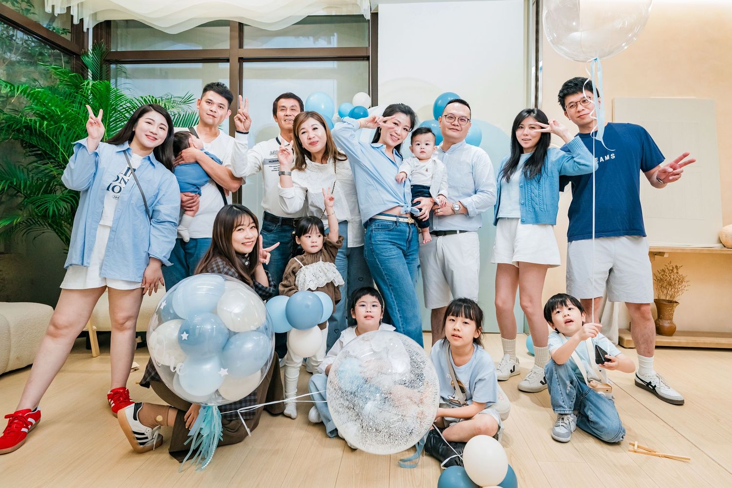 A group of people in light colored clothing posing playfully with large inflatable bubble balls in an indoor space.