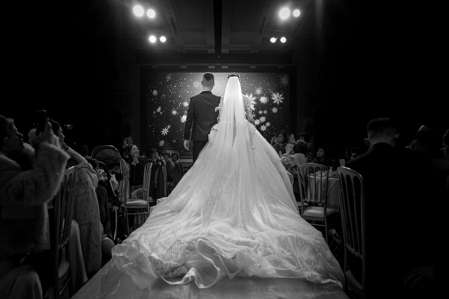 Black and white wedding reception dance floor photos showing silhouettes of guests celebrating and a bride in a flowing gown.