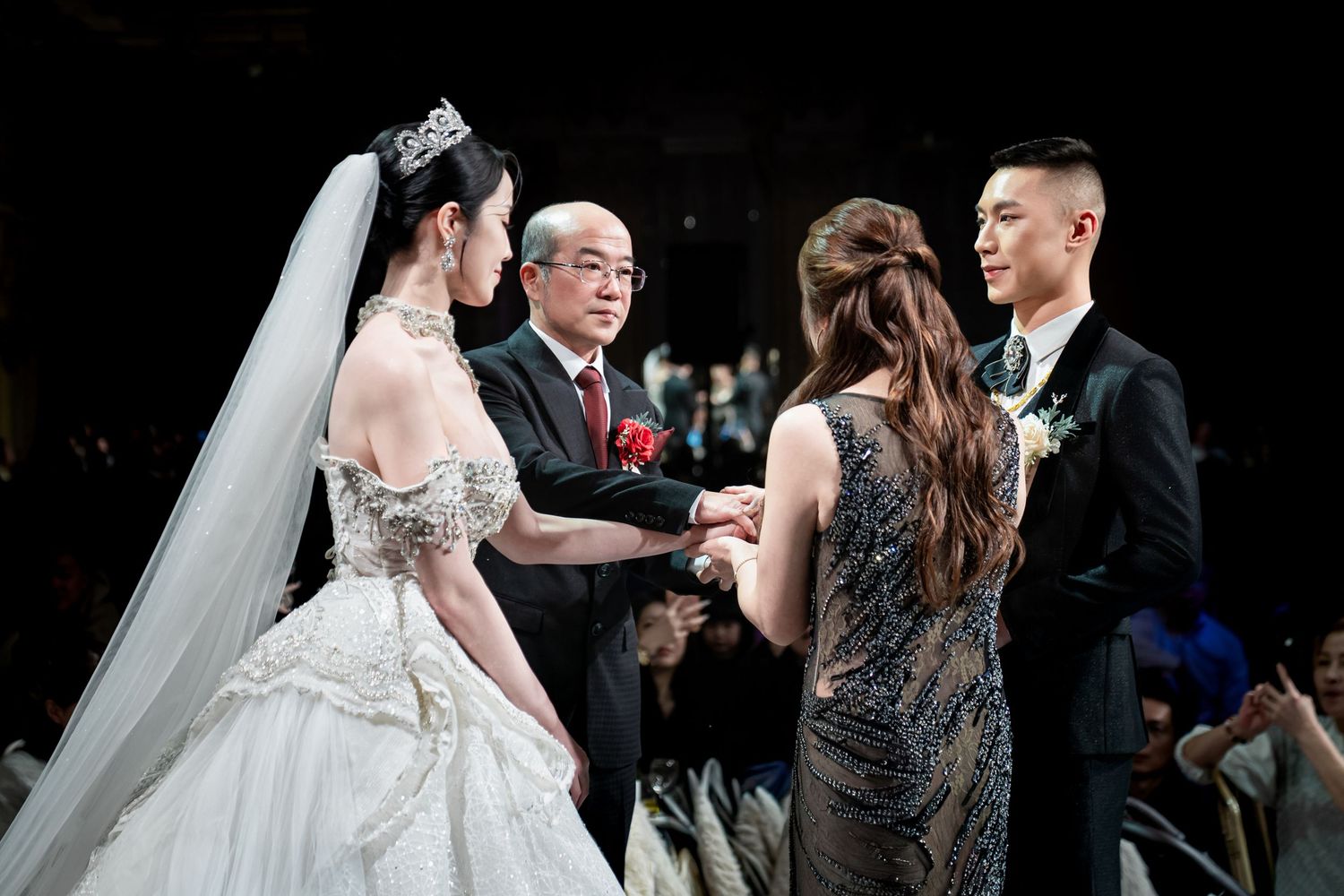 Wedding guests dancing and celebrating on the dance floor at an indoor reception venue.