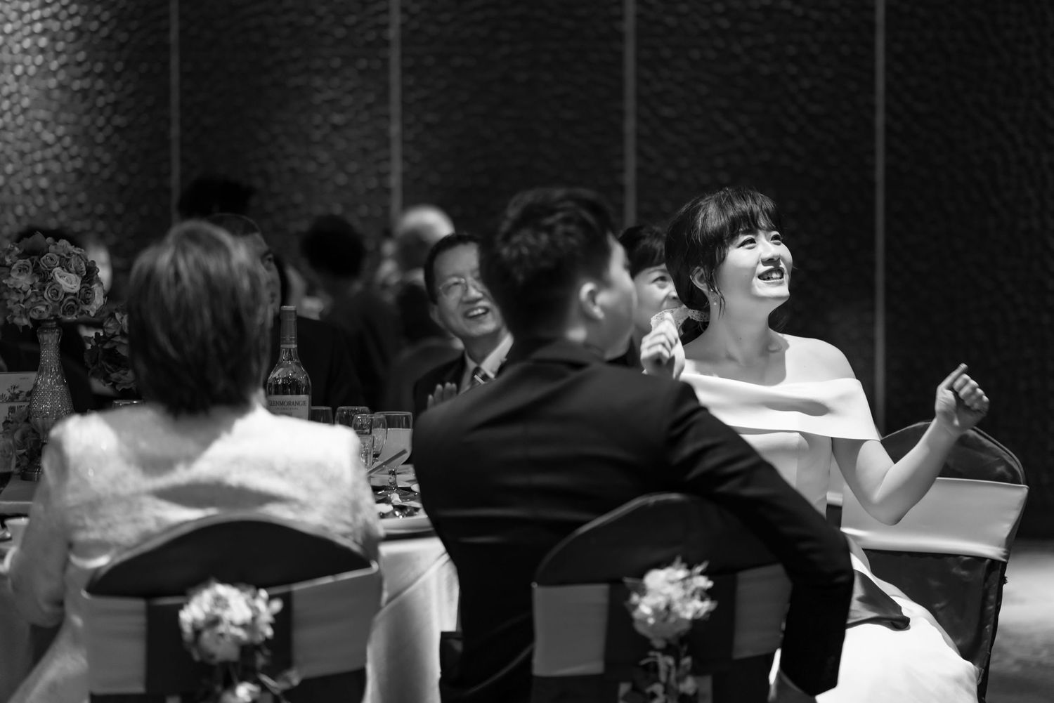 Black and white photo of guests enjoying conversation at a formal dinner reception.