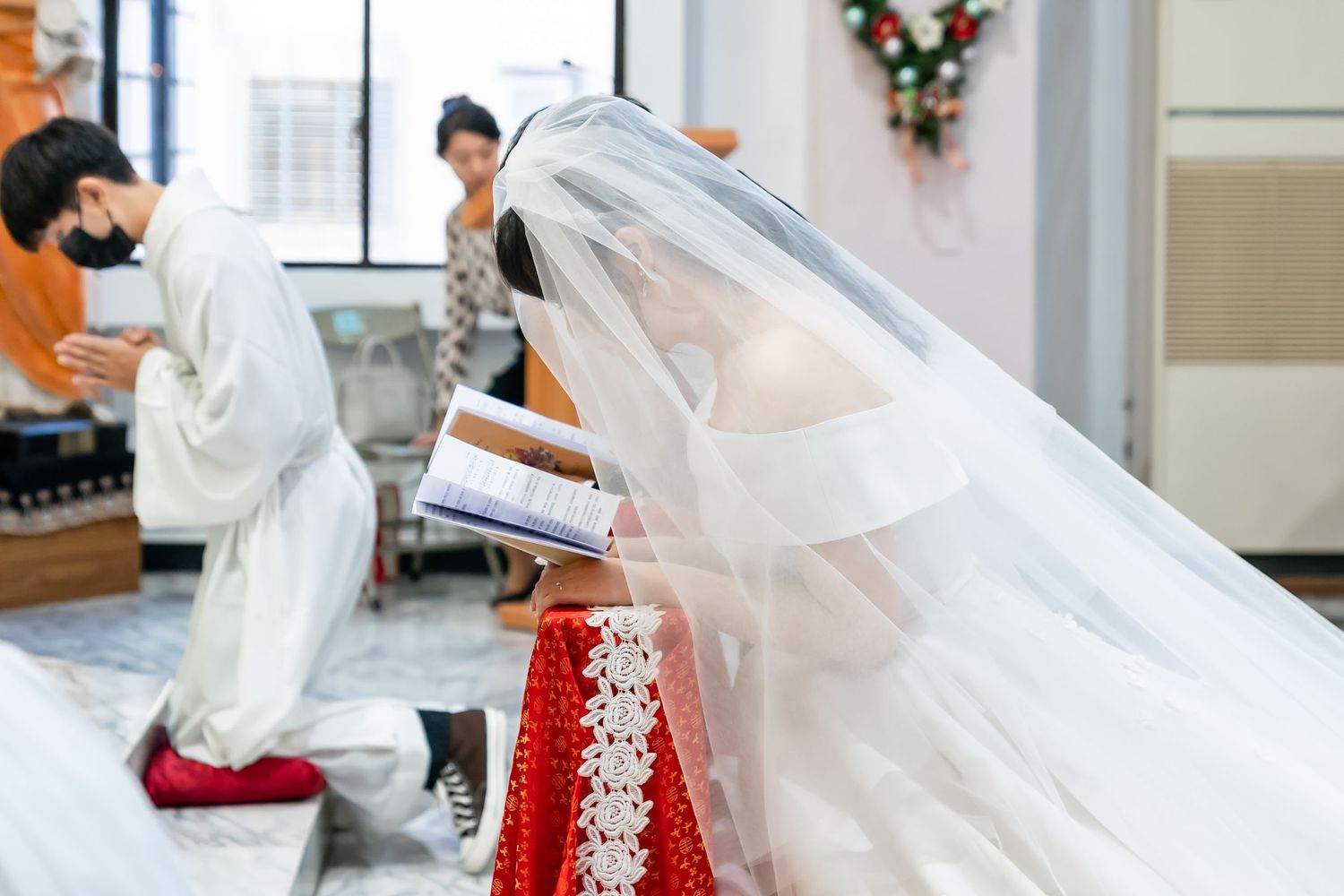 Wedding ceremony detail showing bride's traditional white lace veil.