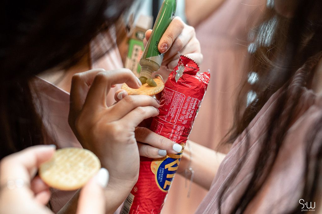 Close-up shot of hands opening snack packages during wedding preparations.