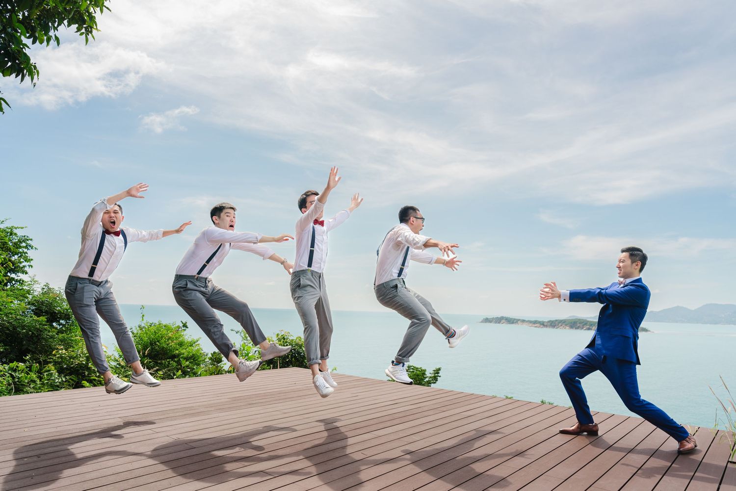Sequence of photos showing a person performing a backflip on a wooden deck with blue sky and trees in background.