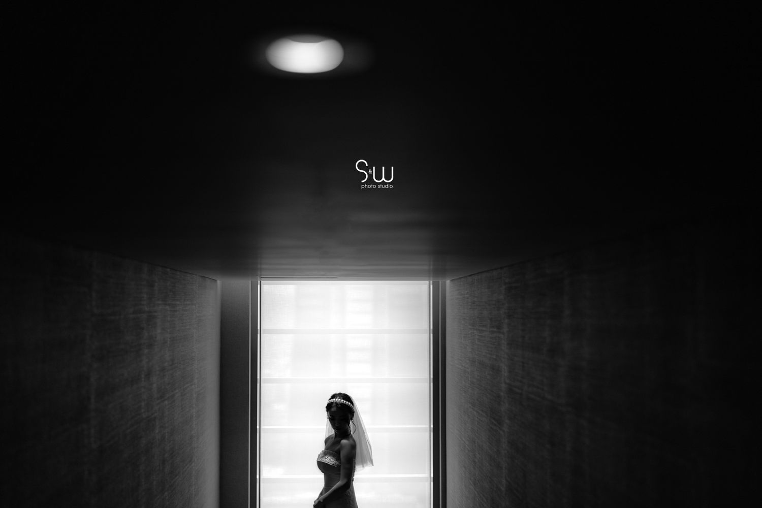 A silhouette of a person standing in a dimly lit corridor with dramatic lighting.