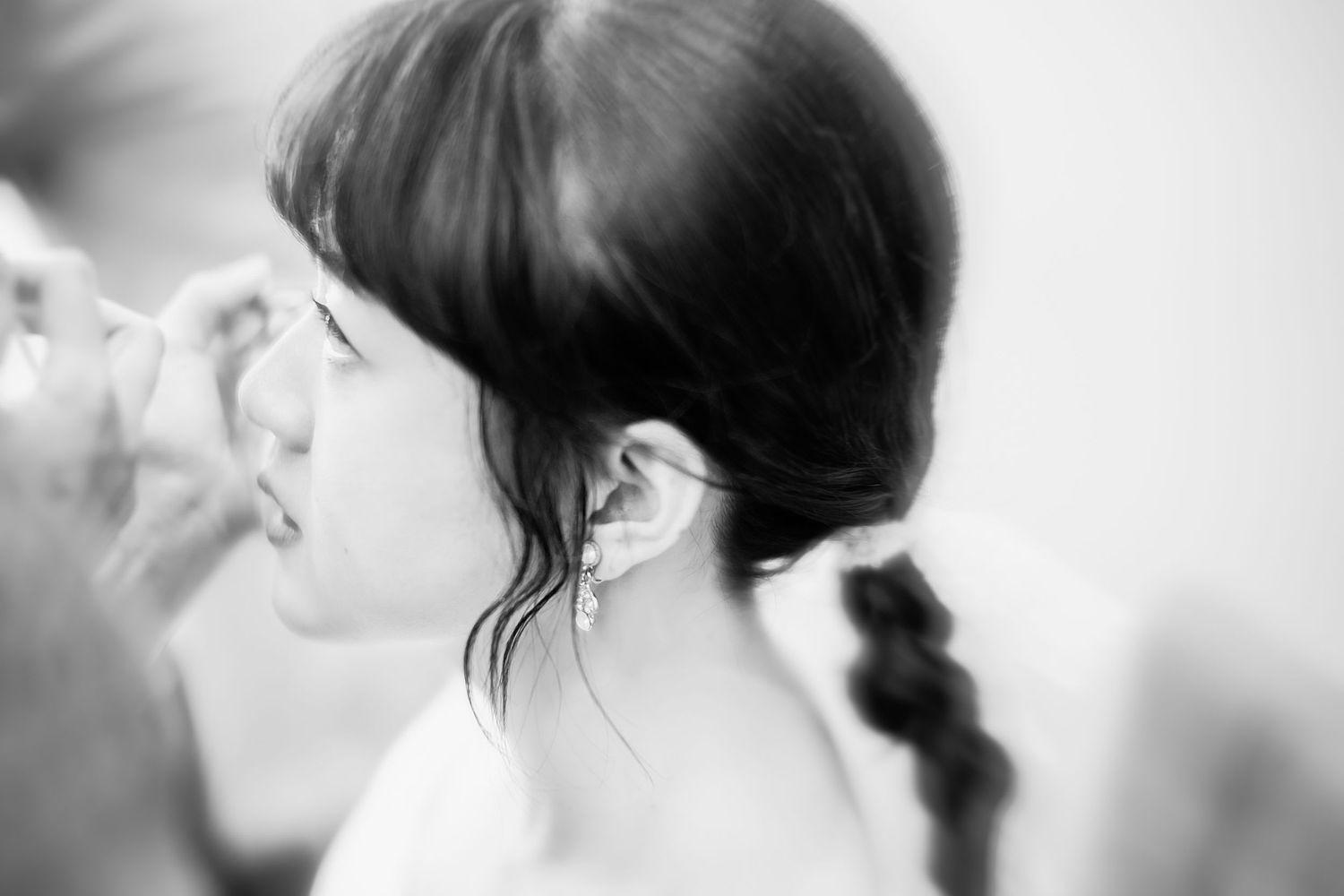 Black and white profile portrait showing elegant hairstyle with wispy bangs.