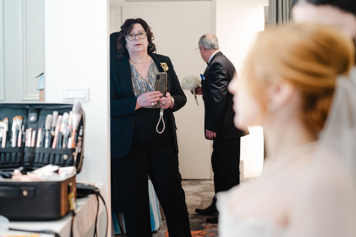 Behind the scenes of wedding preparations with makeup artists and stylists at work.