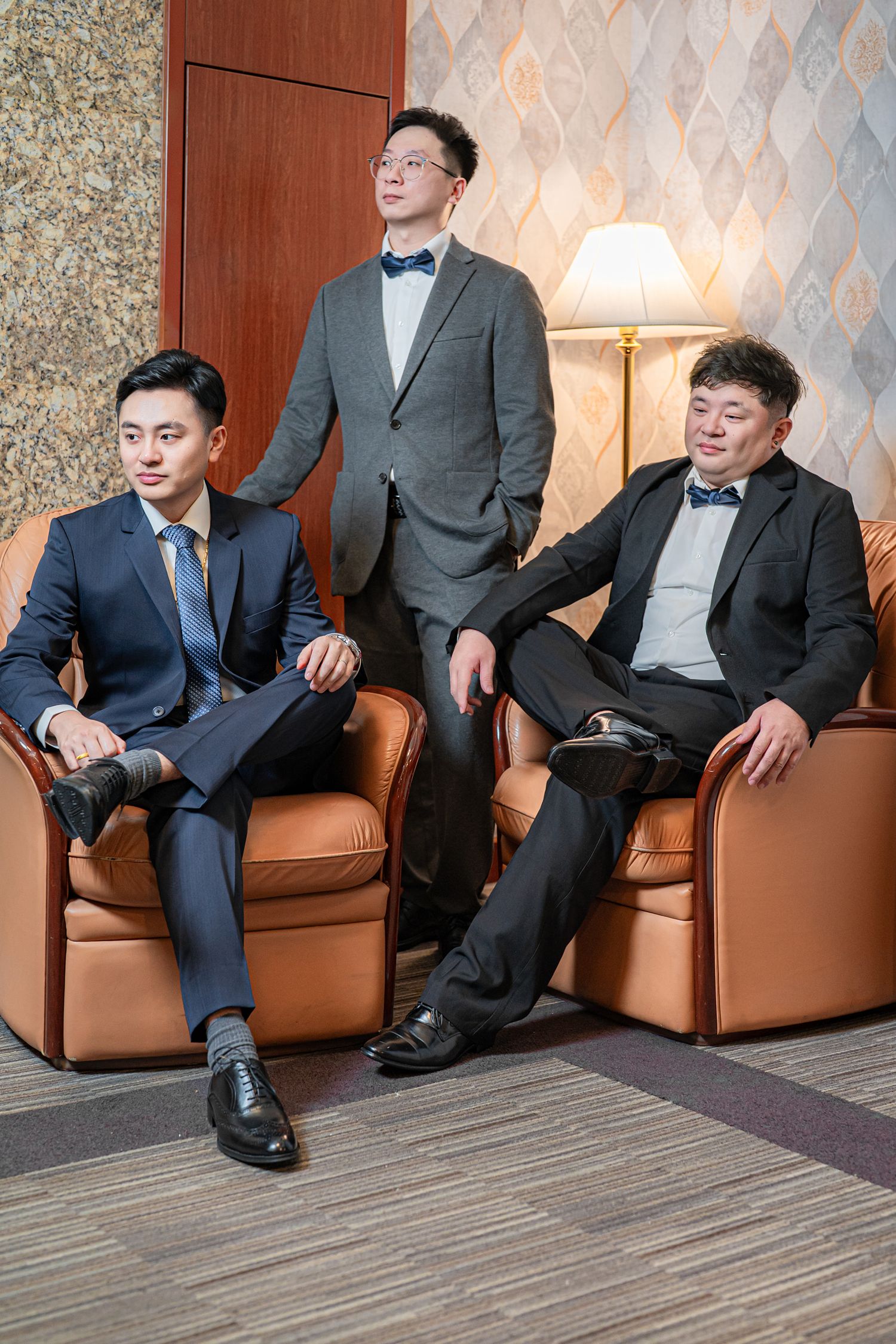A sequence of photos showing people sitting on a brown leather couch in formal attire against a patterned wallpaper.