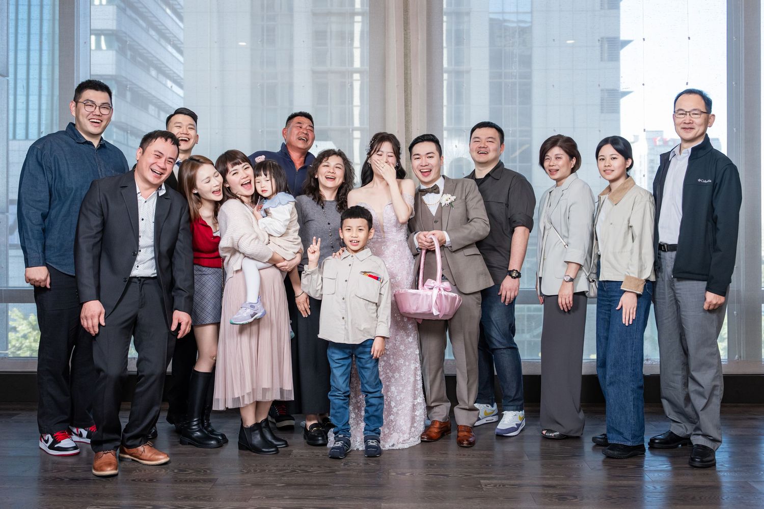 Group of people standing together in a modern building hallway with glass windows and natural lighting.