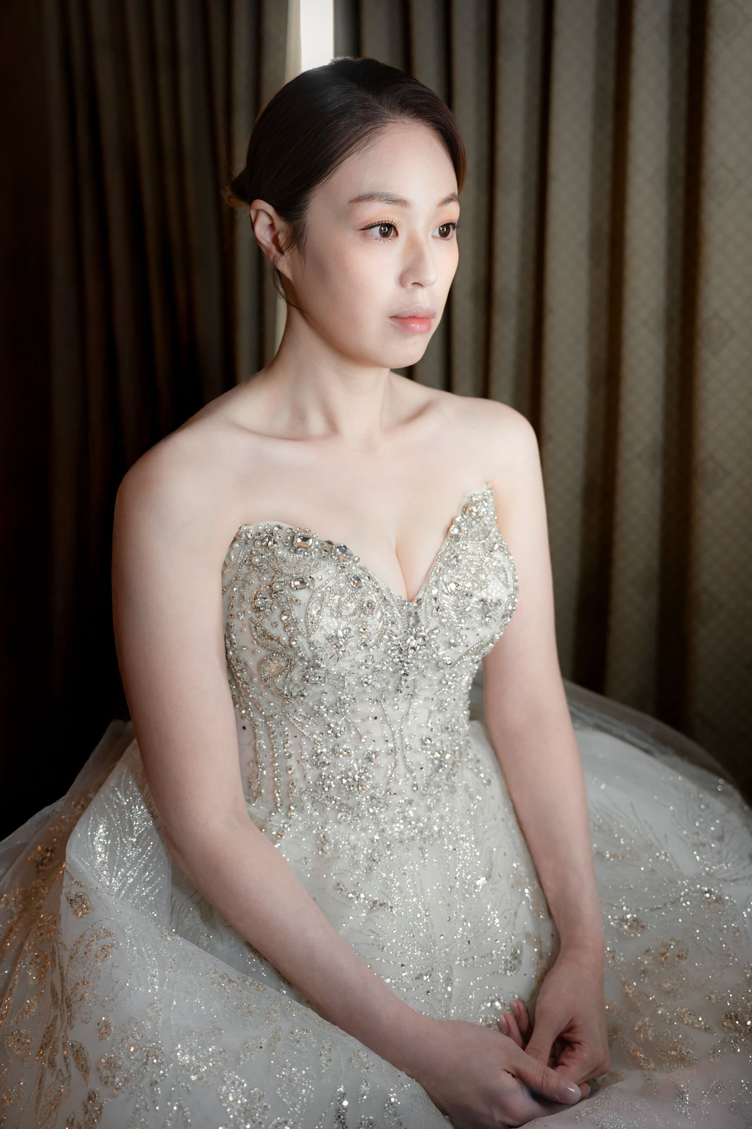 A bride in a sparkling strapless wedding gown with crystal embellishments poses in a series of elegant portraits.