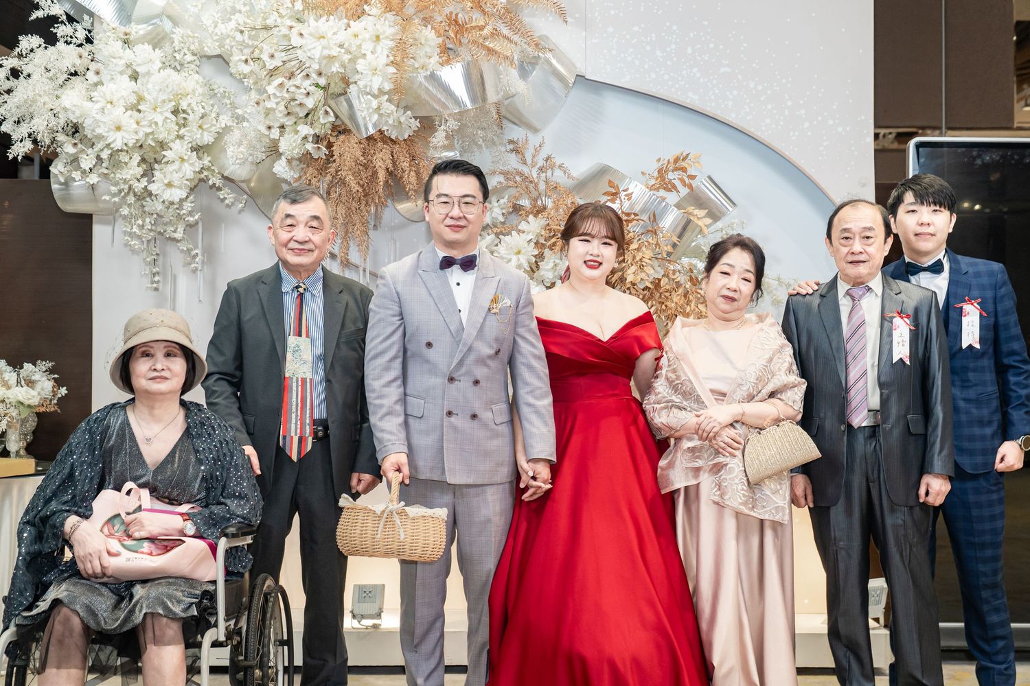 A series of formal wedding party photos arranged in a horizontal collage with people in formal attire and red dresses.