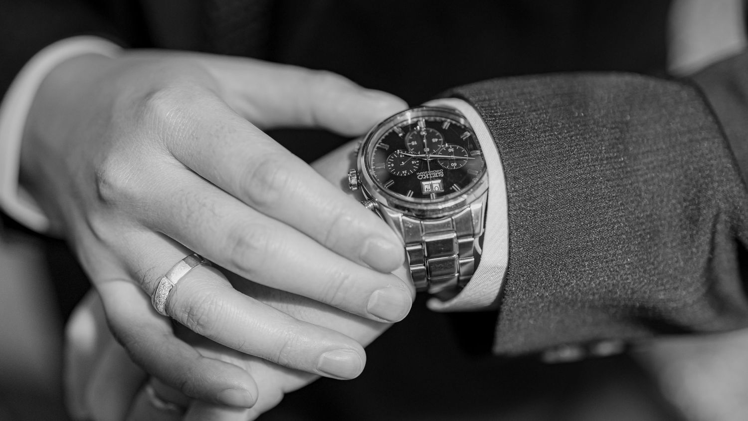 A close-up sequence of hands adjusting and setting time on a luxury wristwatch.