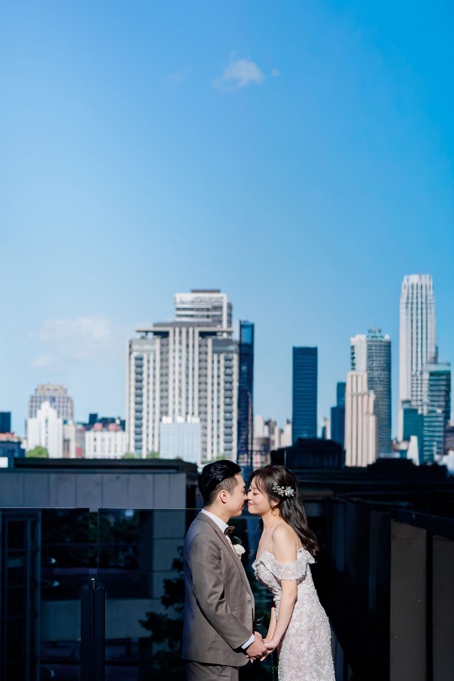 A couple shares a romantic moment on a rooftop with the Chicago skyline visible in the background on a sunny day.