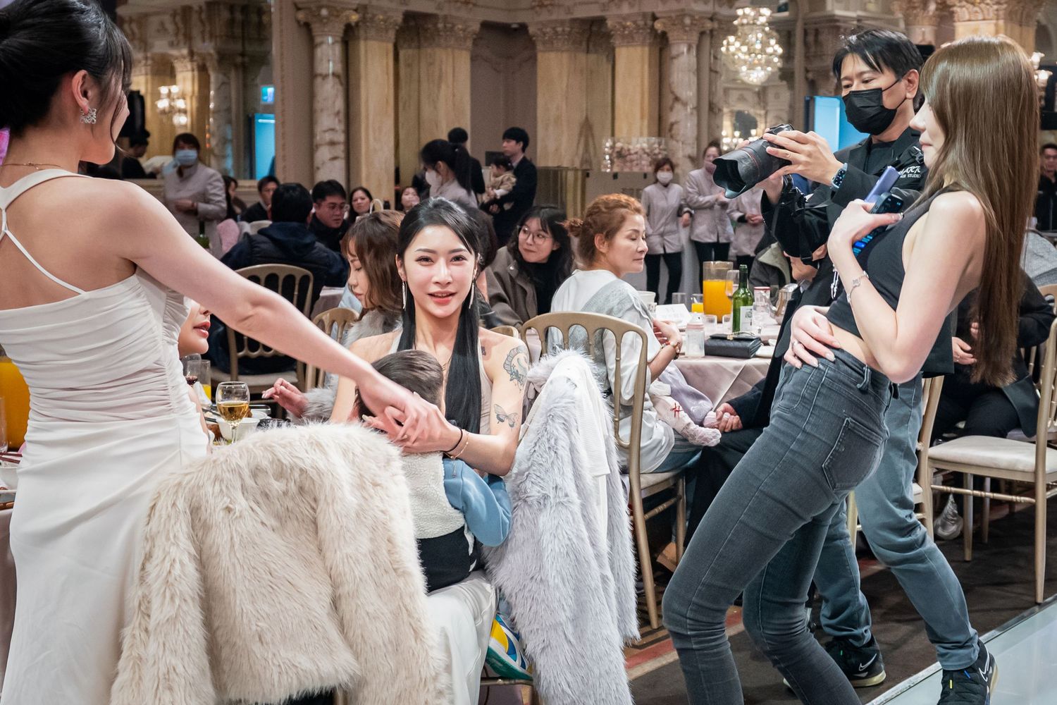 Couples practice dancing together in a group dance class setting at a social gathering.