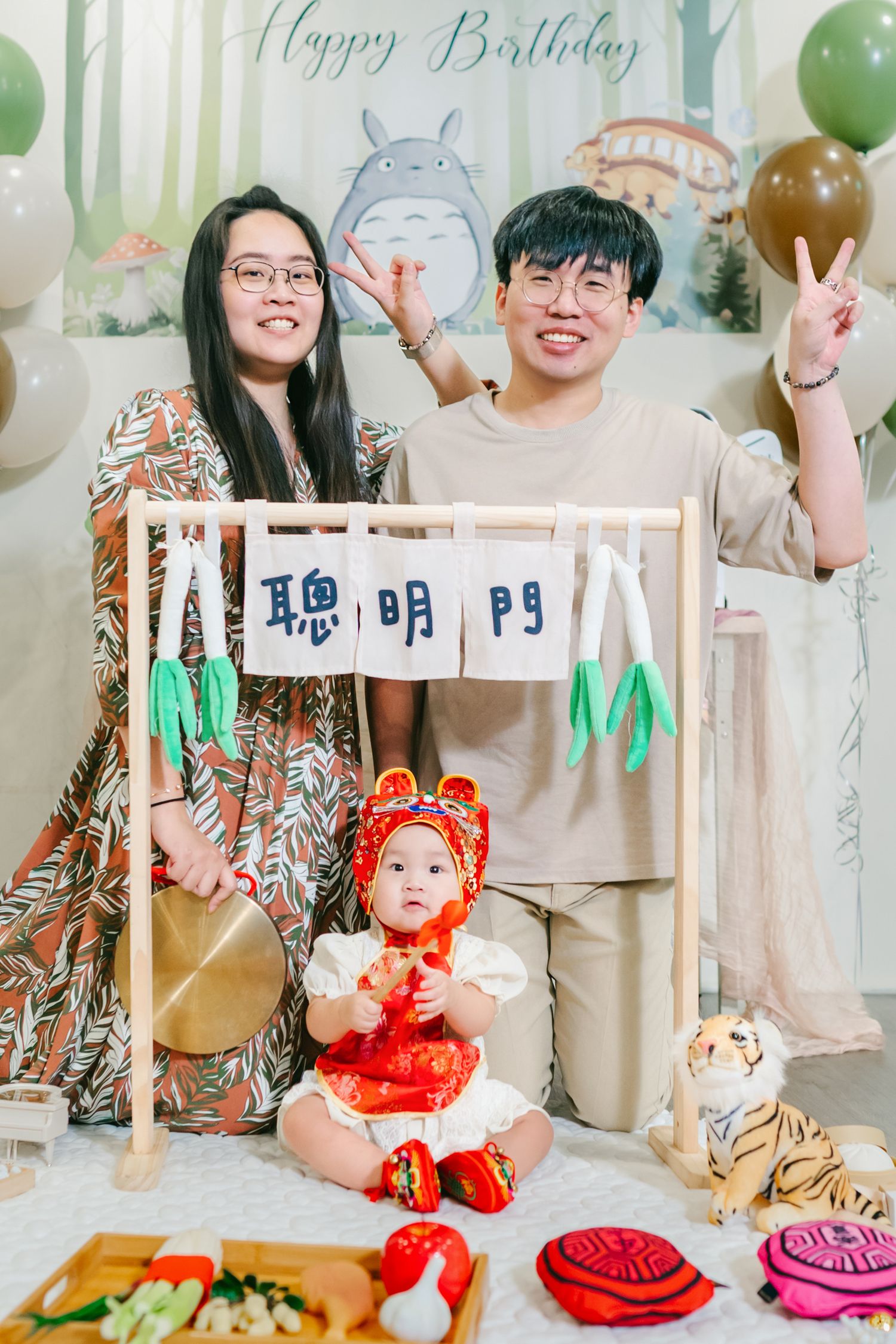 A birthday celebration setup with plush toys, colorful balloons, and party decorations in a bright indoor setting.