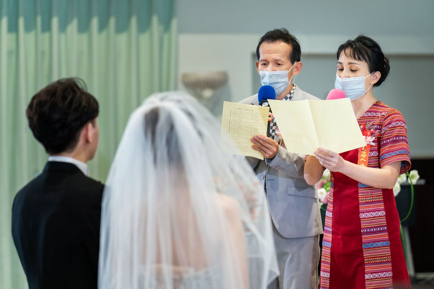 Indoor wedding ceremony with participants wearing protective masks.