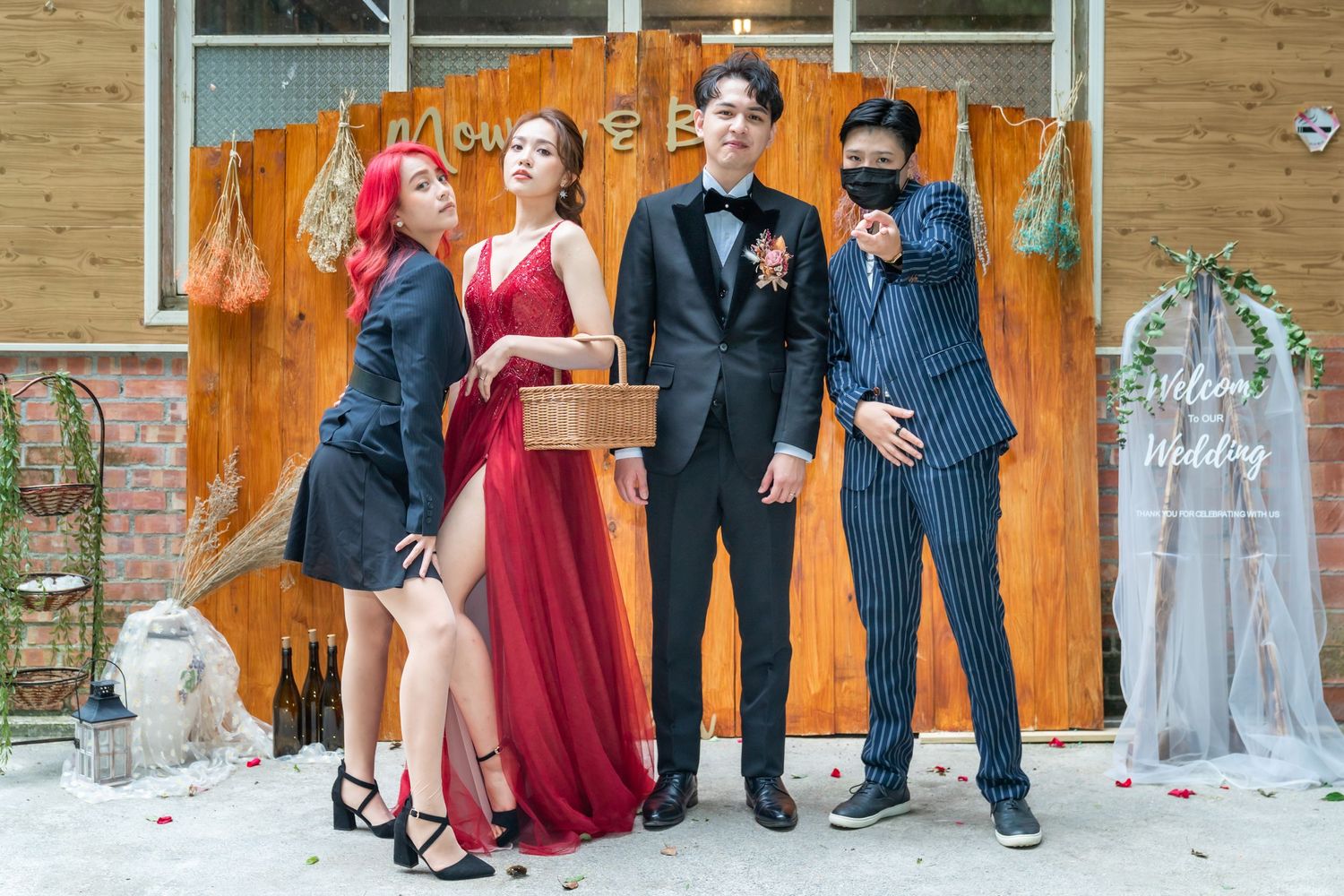 A stylish group in formal wear poses against an orange backdrop with decorative elements.