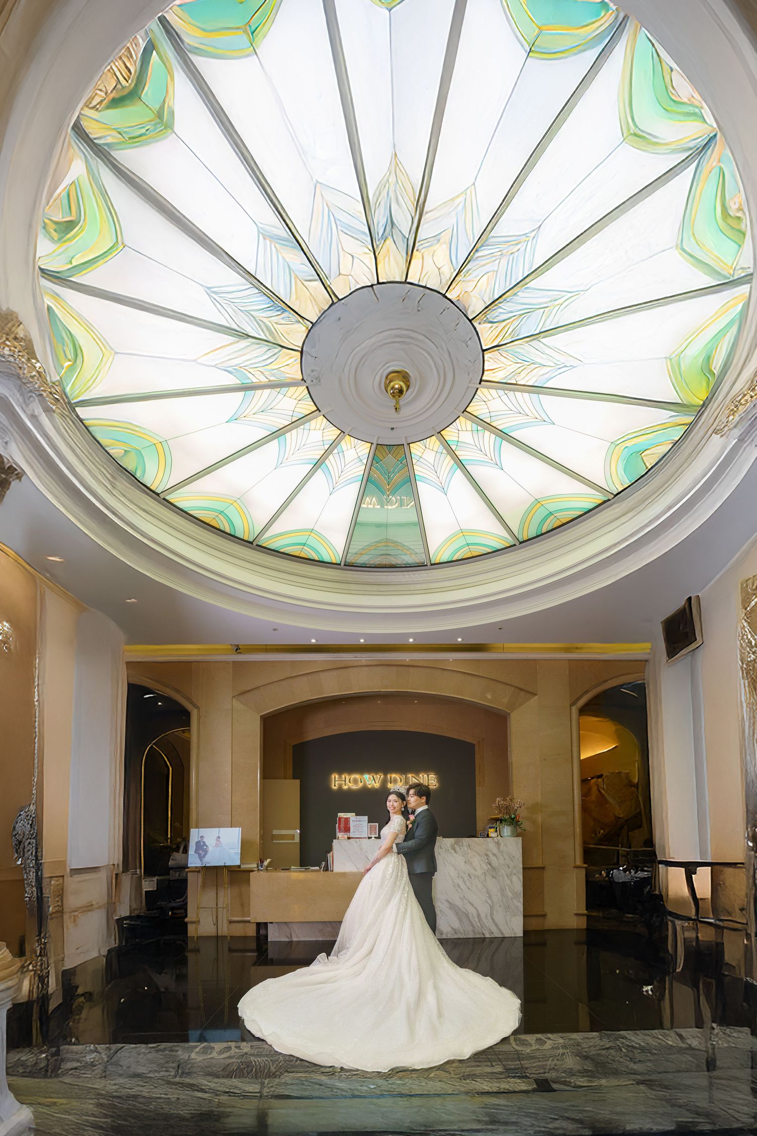 Elegant wedding venue featuring a stunning Art Deco-style dome ceiling with turquoise and cream stained glass sunburst design.