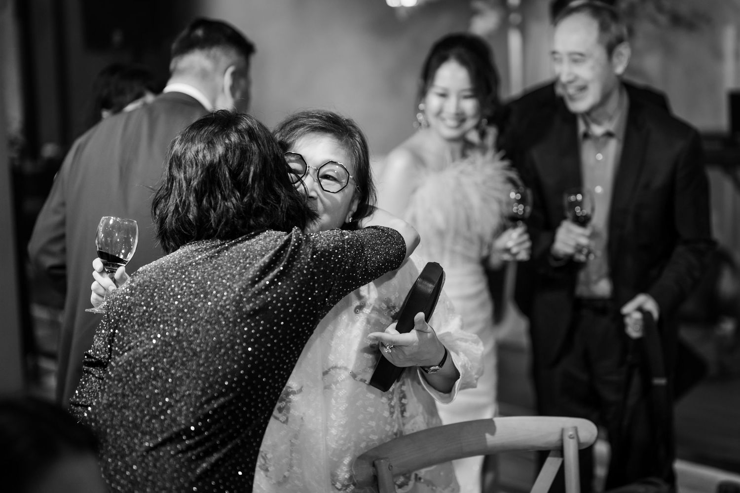 A collection of black and white photos showing wedding guests dancing and celebrating at a reception.
