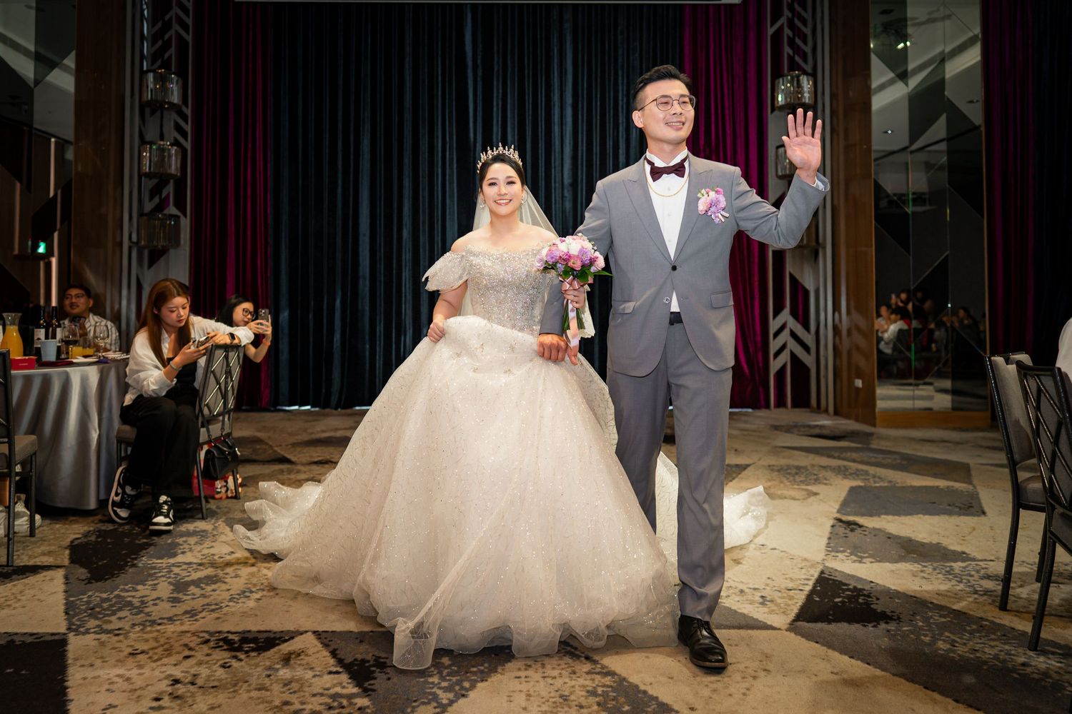 A wedding celebration at an elegant venue with a couple exiting down the aisle after their ceremony.