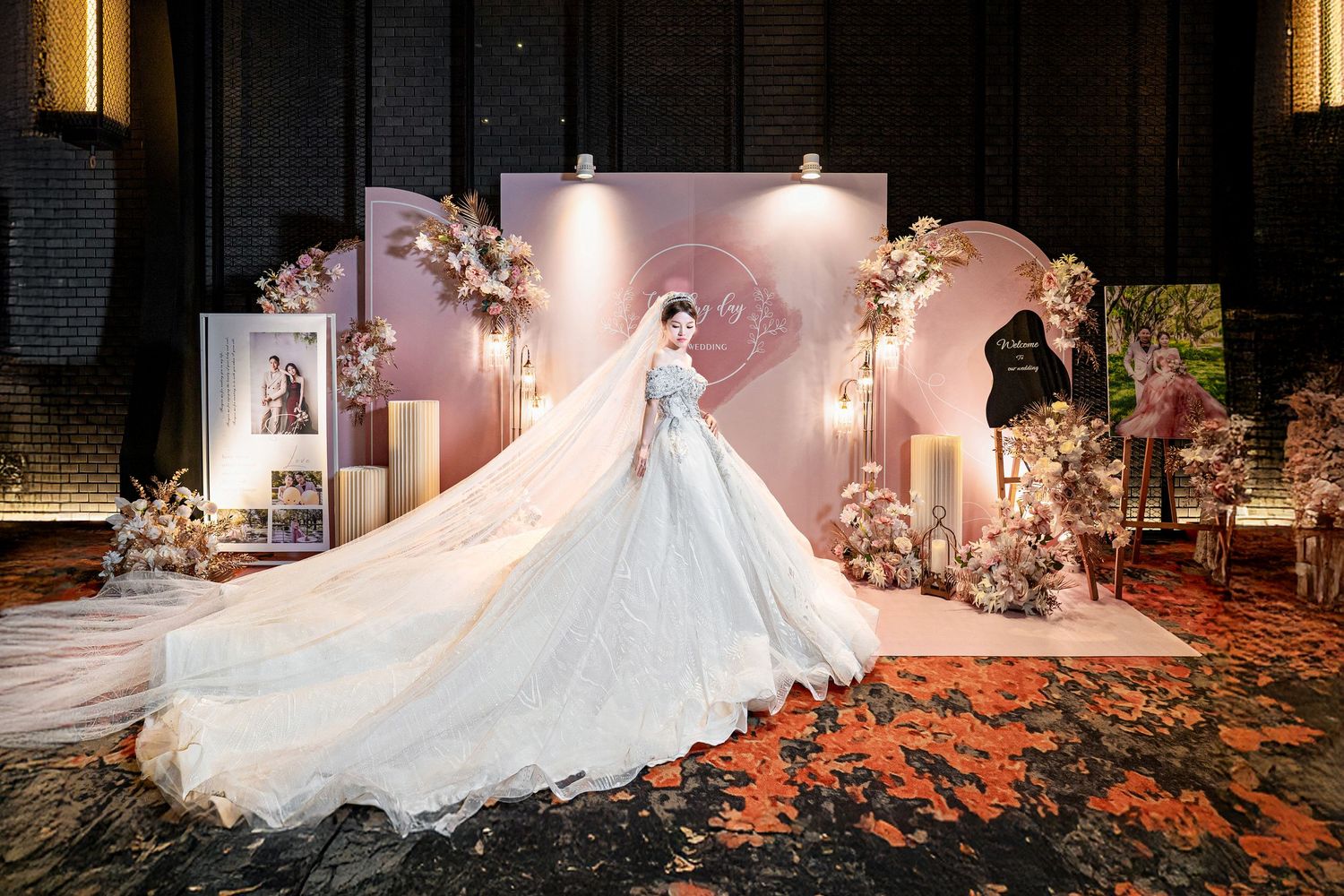 A flowing white wedding dress train trails elegantly across autumn leaves on the ground in dramatic lighting.
