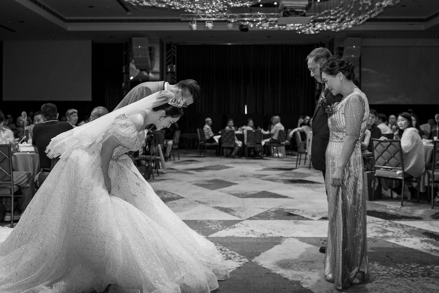 A bride in a flowing white wedding dress twirls gracefully on an elegant ballroom dance floor.