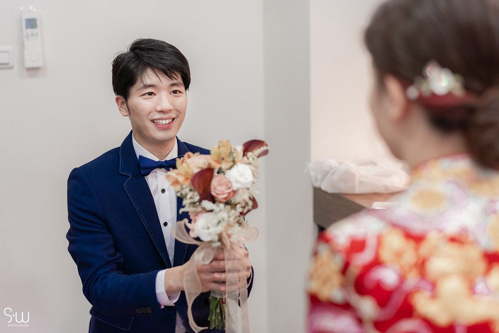 Sweet moment during Chinese wedding with exchange of flowers and traditional dress.