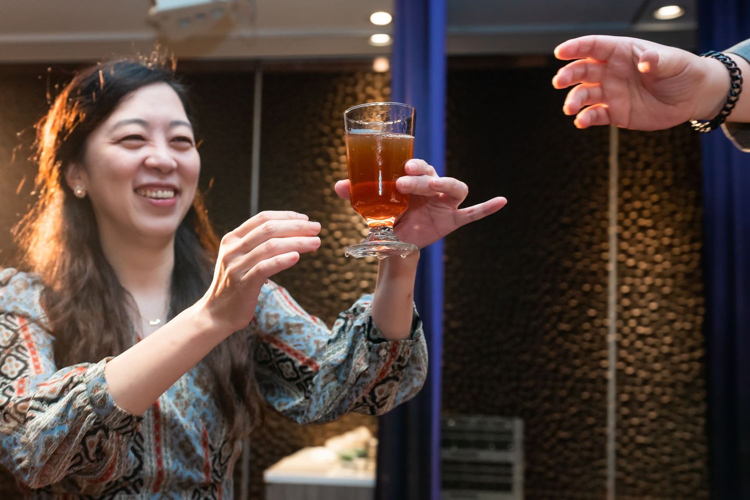 A guest at a wedding reception reaches for a drink being passed to them.