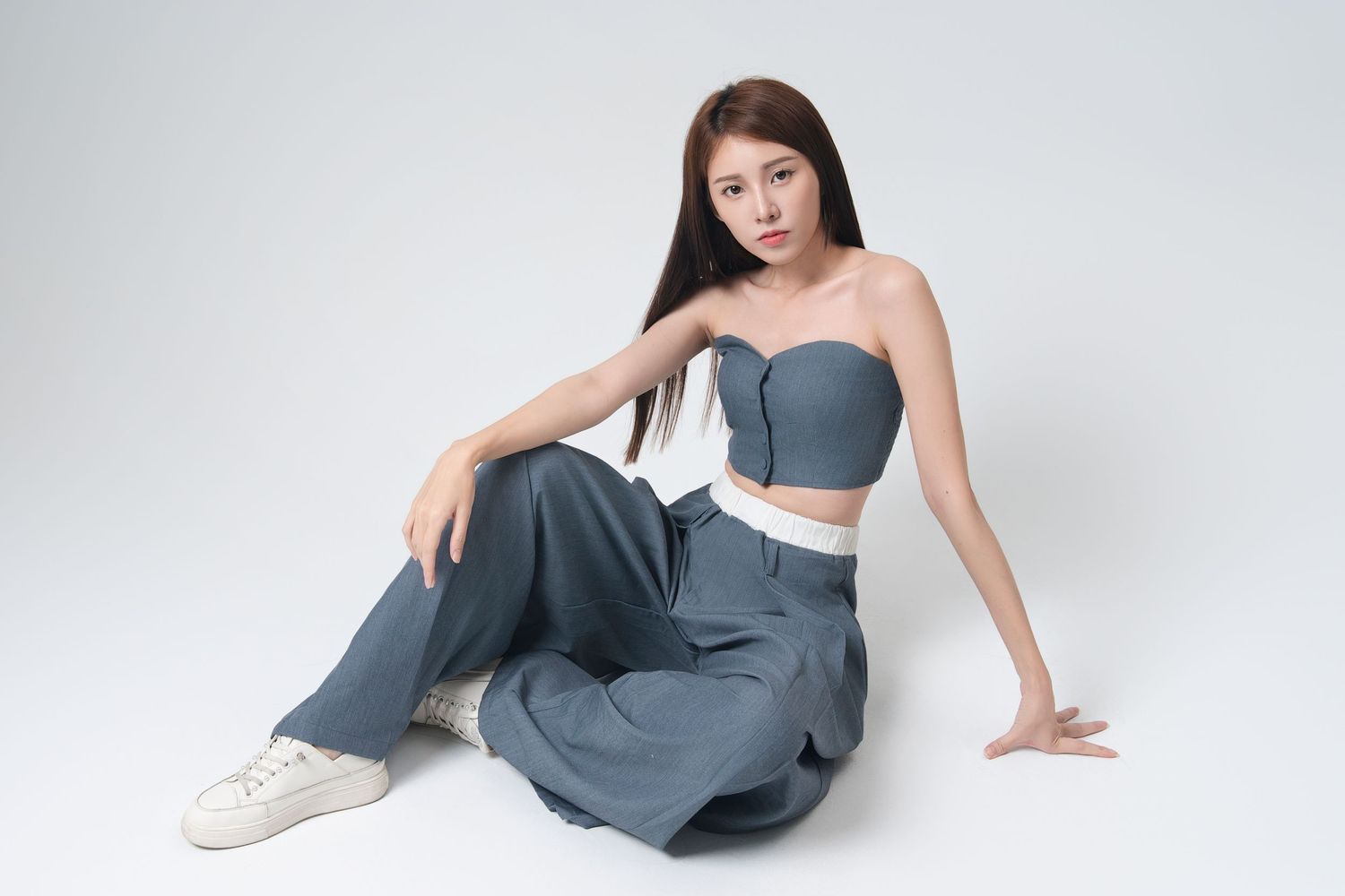 A person in a grey dress poses gracefully on a white background in a series of artistic fashion shots.