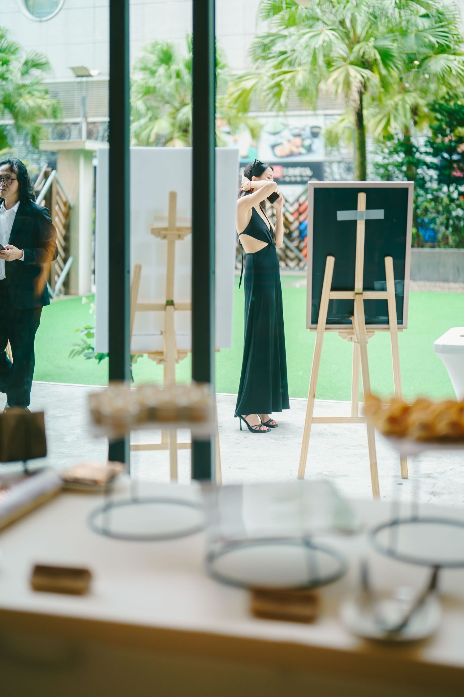Small display easels with decorative signage and glass jars line a windowsill in a bright indoor venue.