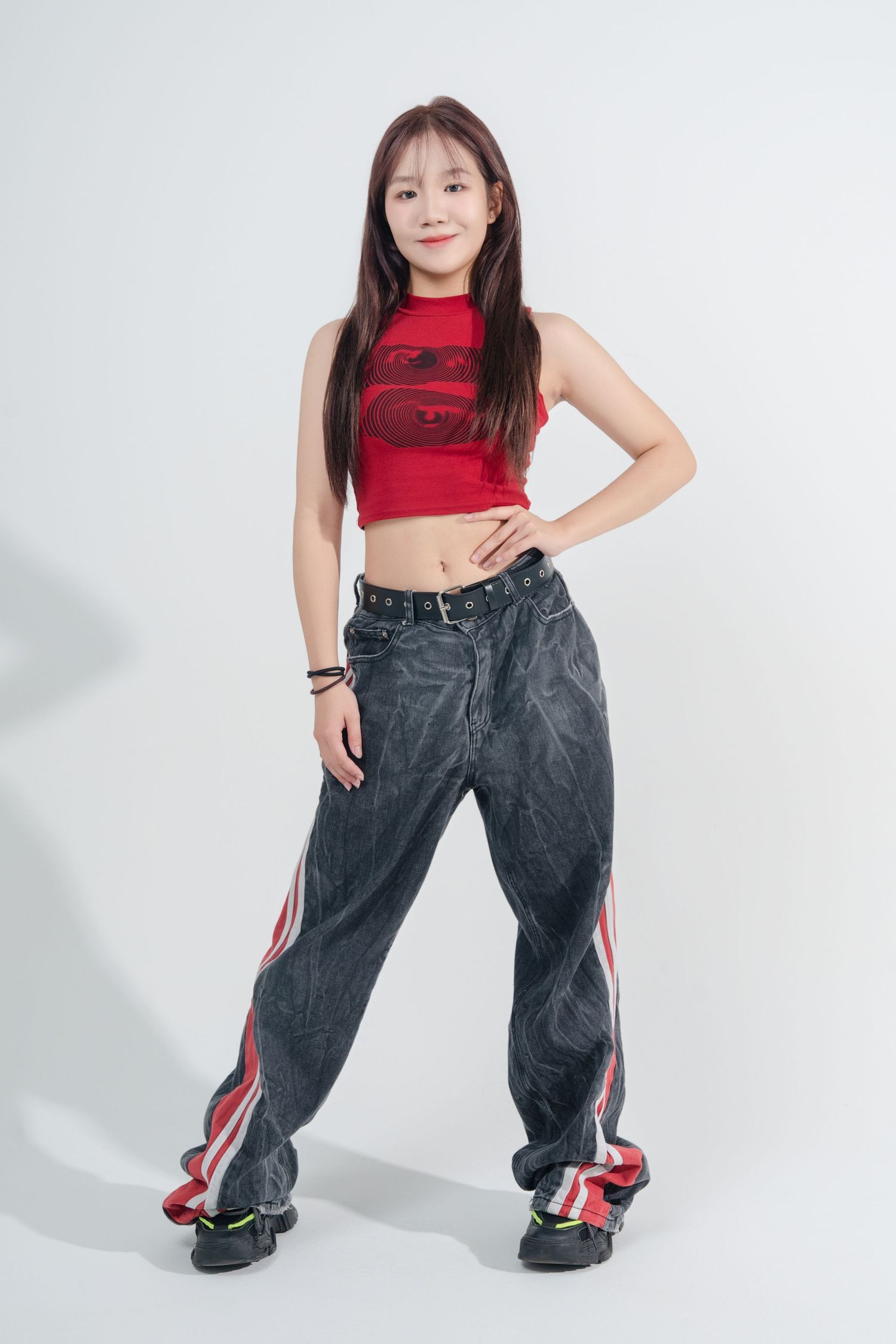 A person in a red crop top and baggy gray pants strikes dynamic dance poses against a white background.