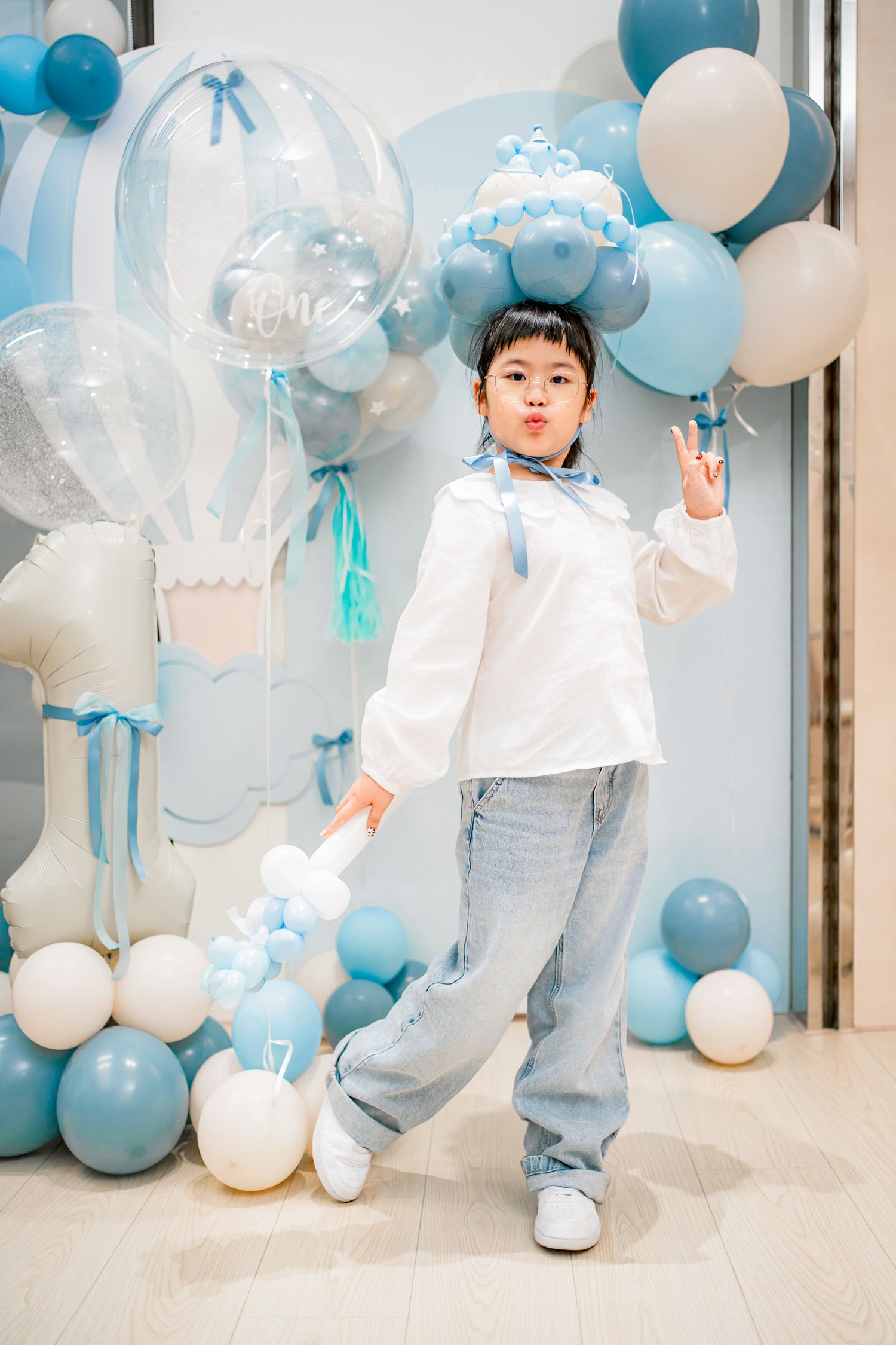 A festive party setup with blue and white balloons creating an elegant backdrop for a special celebration.