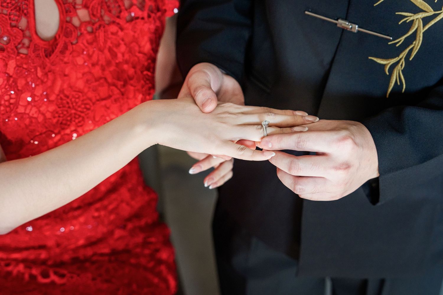 Hands performing traditional Chinese tea ceremony with bamboo whisk and red velvet backdrop.