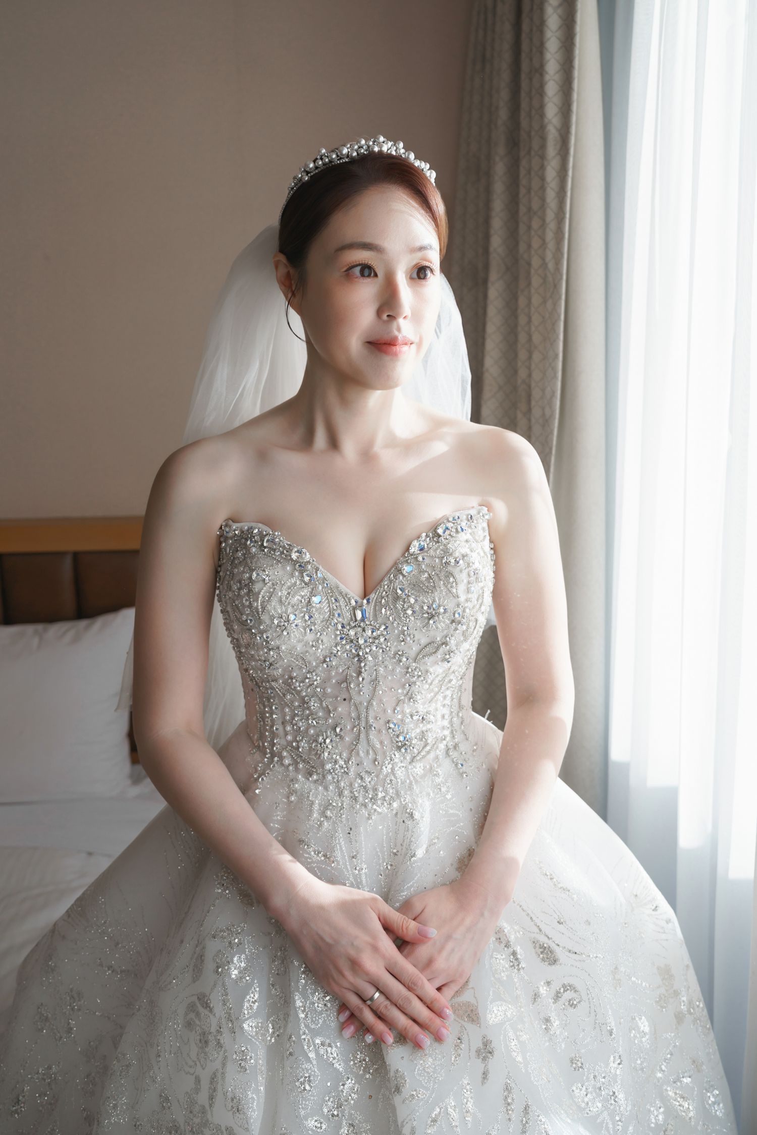 Close-up details of a stunning beaded white wedding gown with sweetheart neckline and intricate crystal embellishments.