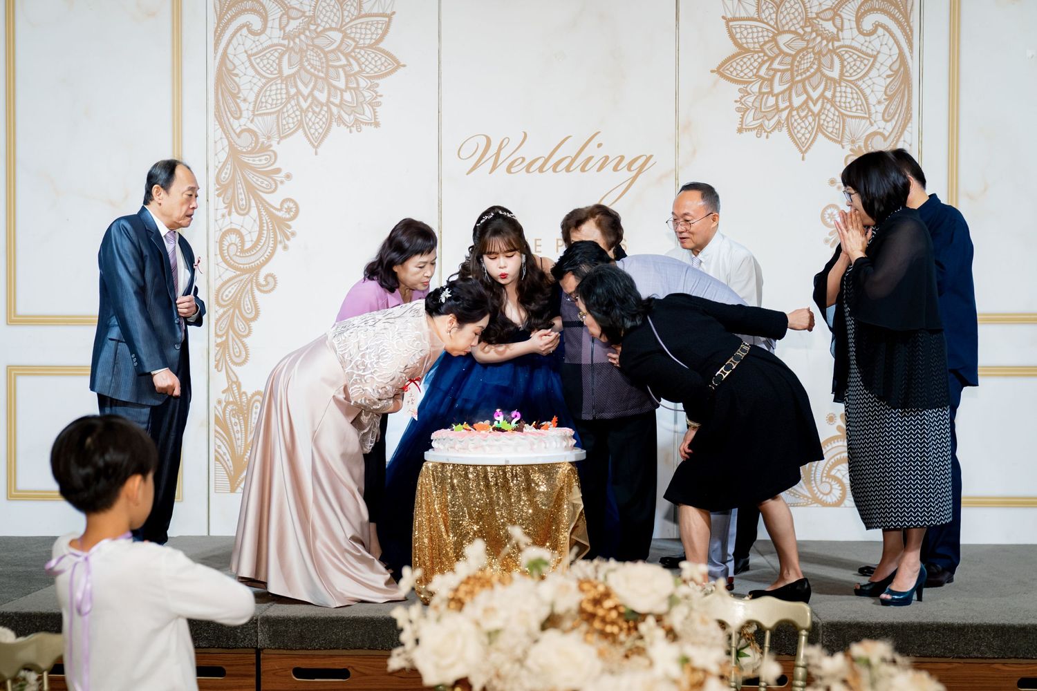 A collage of wedding reception photos showing guests gathering around a dessert table with elegant decor and ornate details.