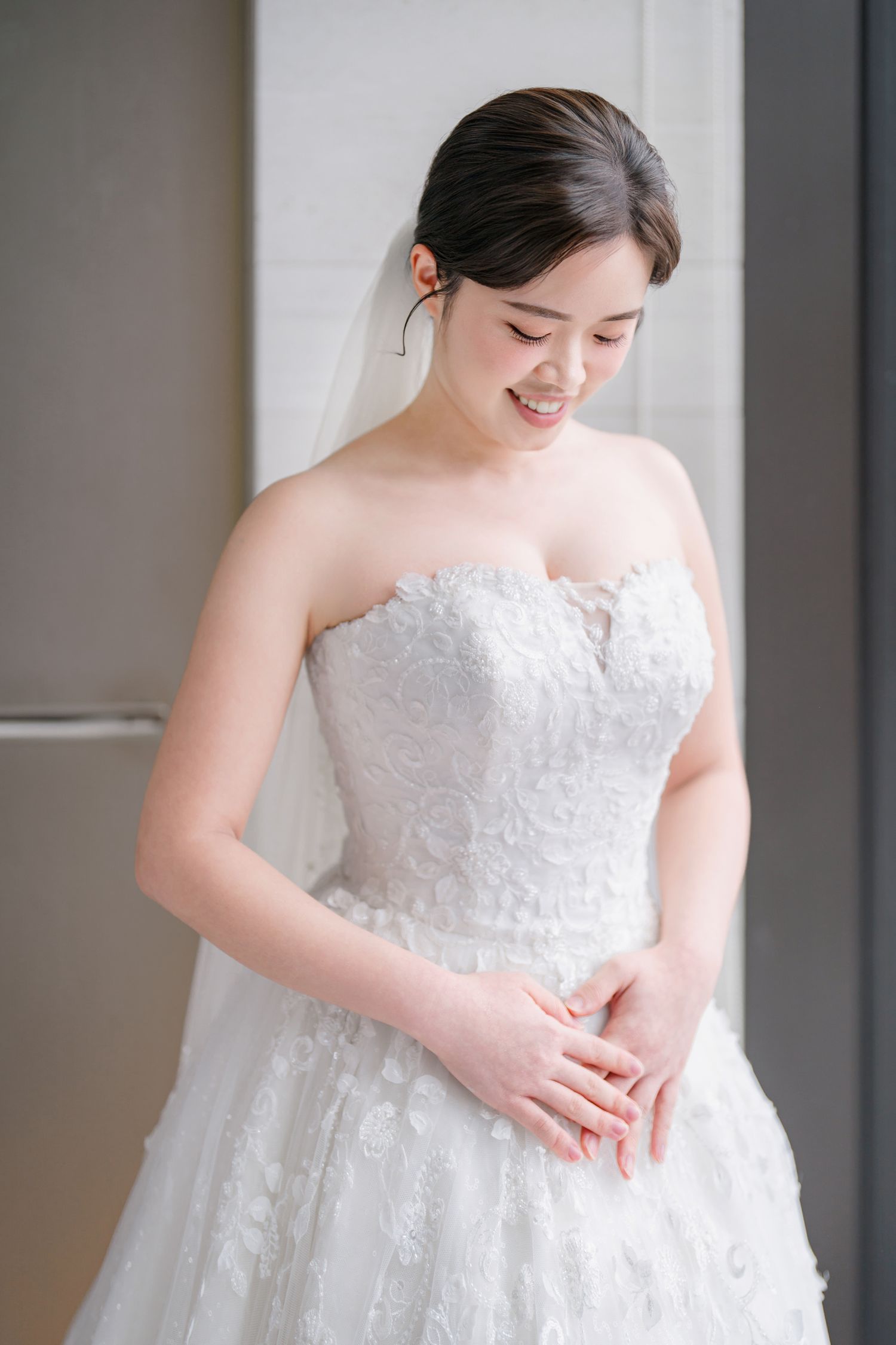 Close-up details of an elegant white lace wedding dress with delicate embellishments.