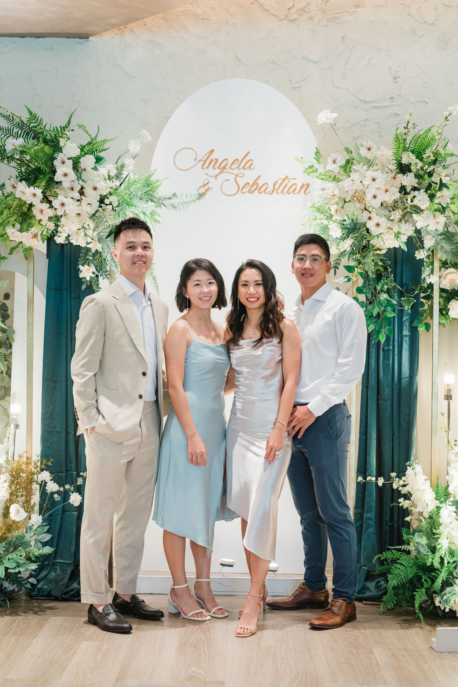 Family photo session capturing groups in light blue and white attire against floral arch backdrop in backyard setting.