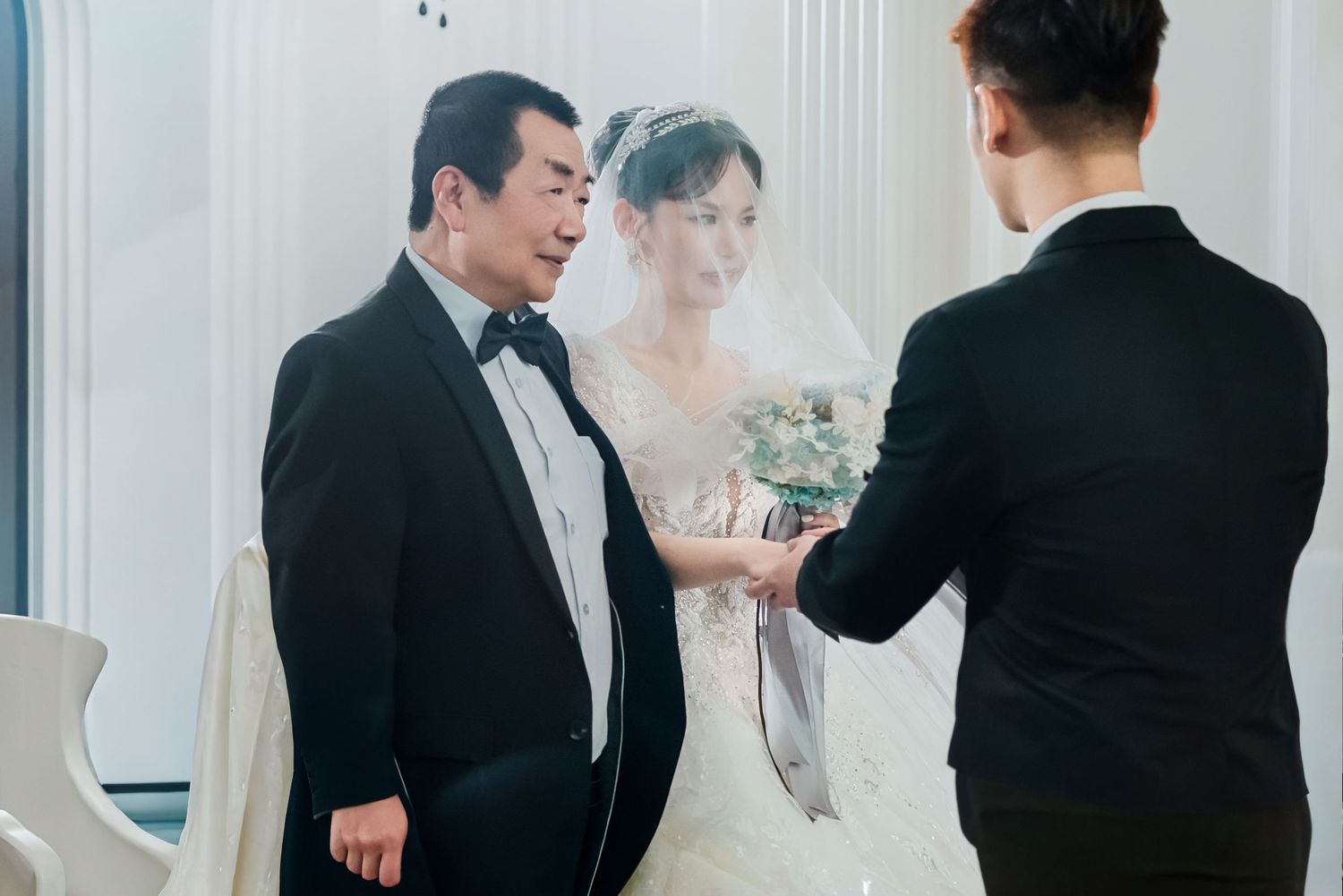 Wedding party members in formal attire gather together in an elegant indoor venue during a celebration.