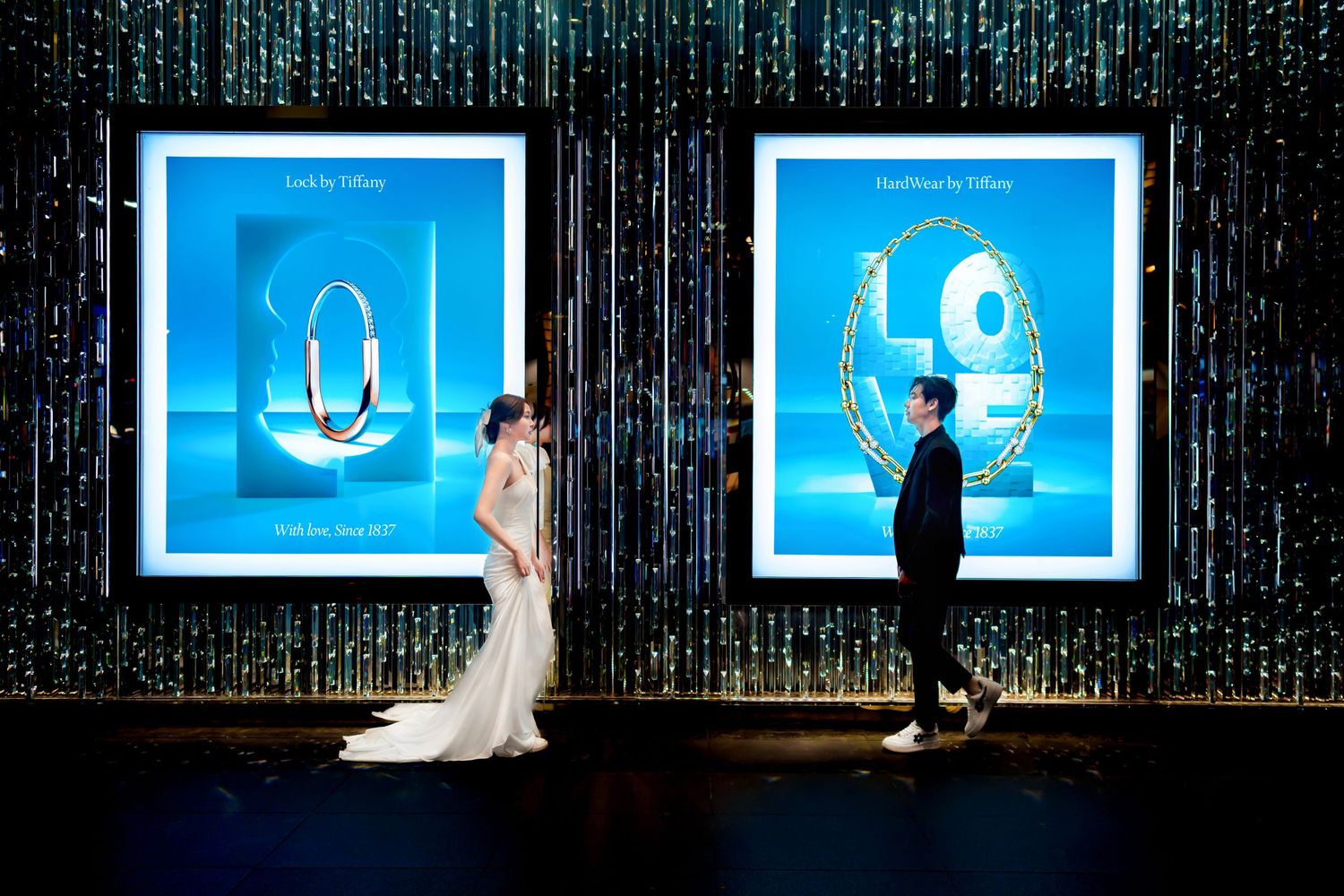 A sequence of illuminated blue frames showing silhouettes interacting with digital art in a dark gallery space.