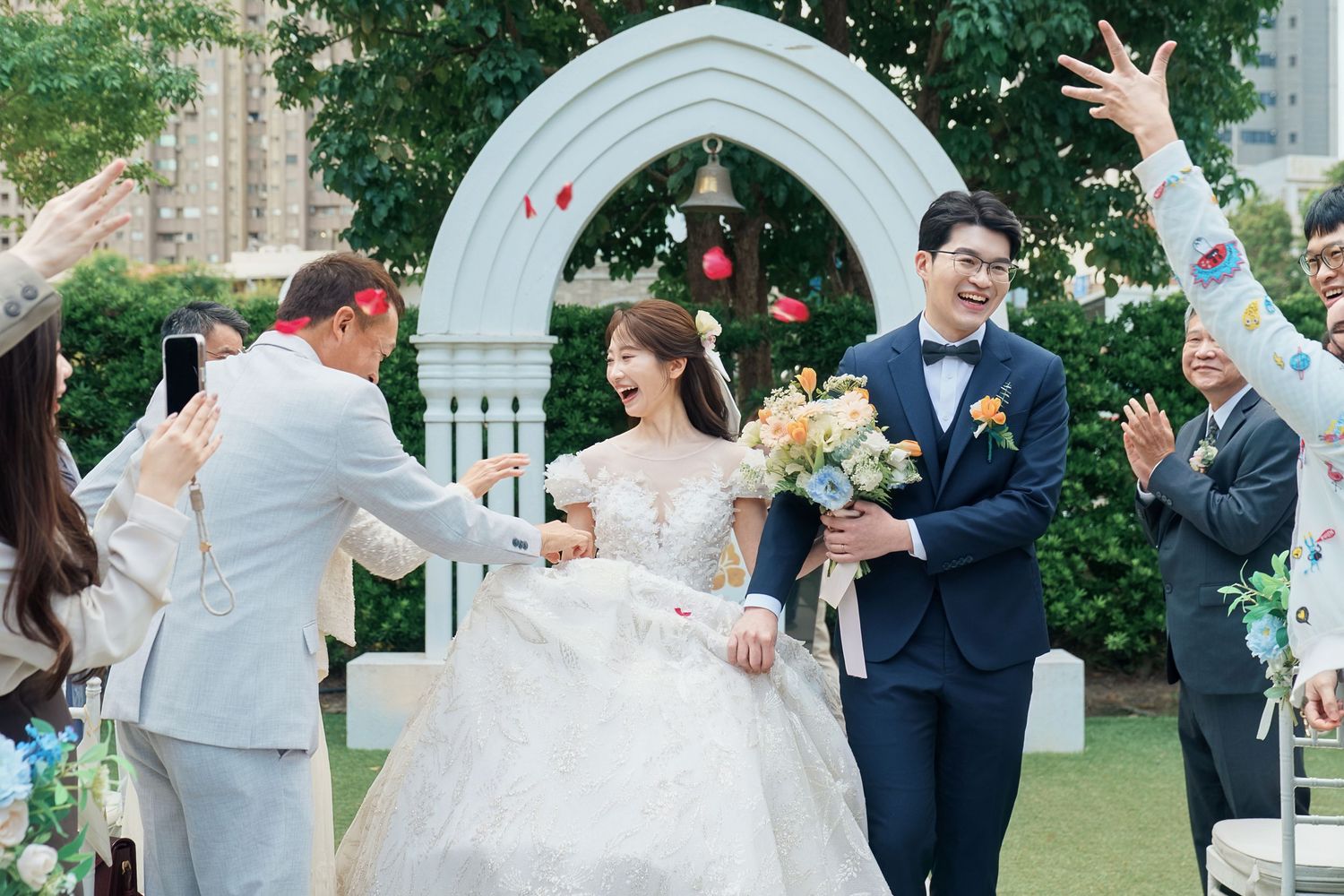 A joyful wedding celebration sequence showing dancing and embracing moments in an outdoor garden setting.